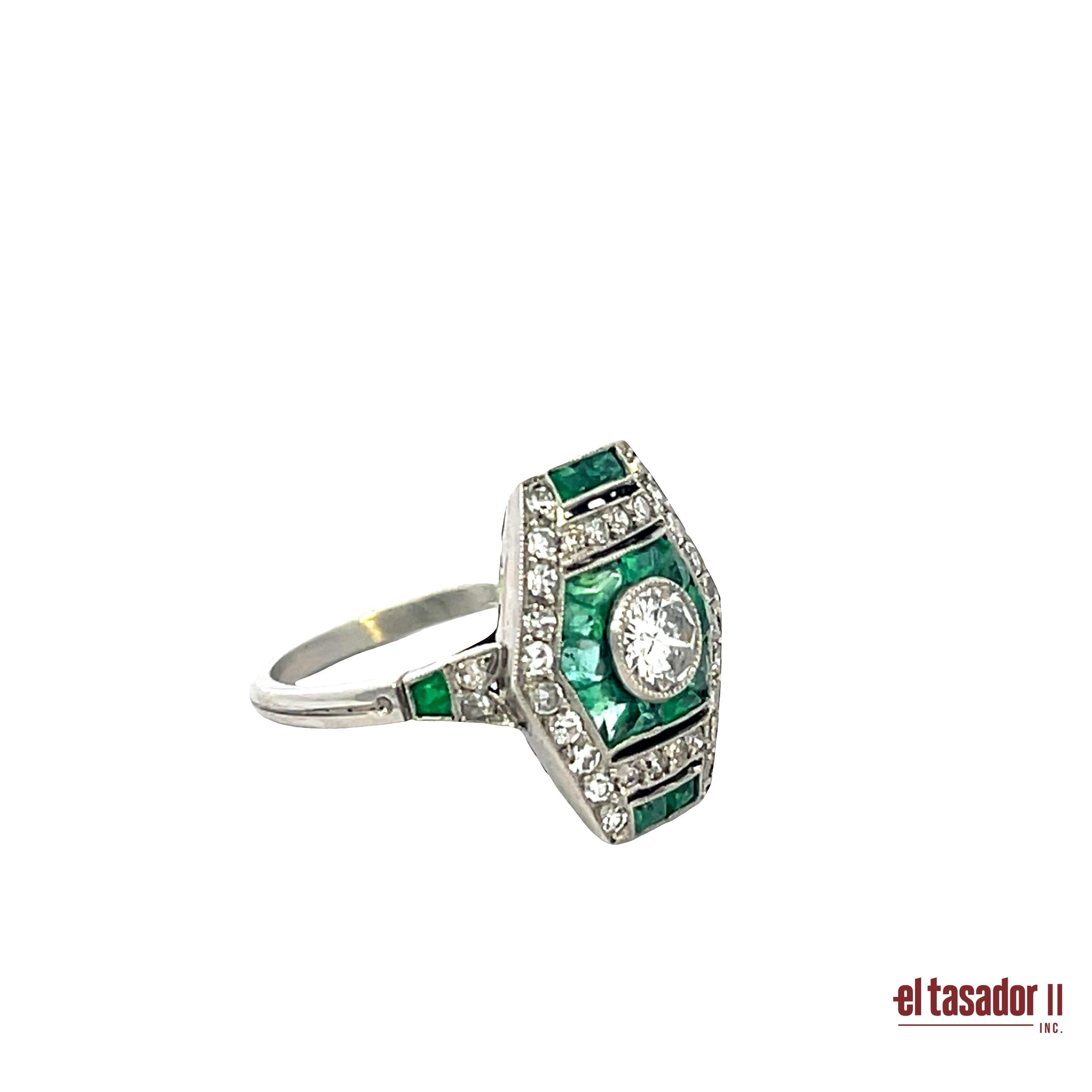Cette bague en platine présente une silhouette géométrique saisissante inspirée des designs antiques de l'Art déco. Au centre, un diamant de 0,34 carat taillé en brillant rayonne, encadré par 1,98 carat d'émeraudes vives taillées en calibre et