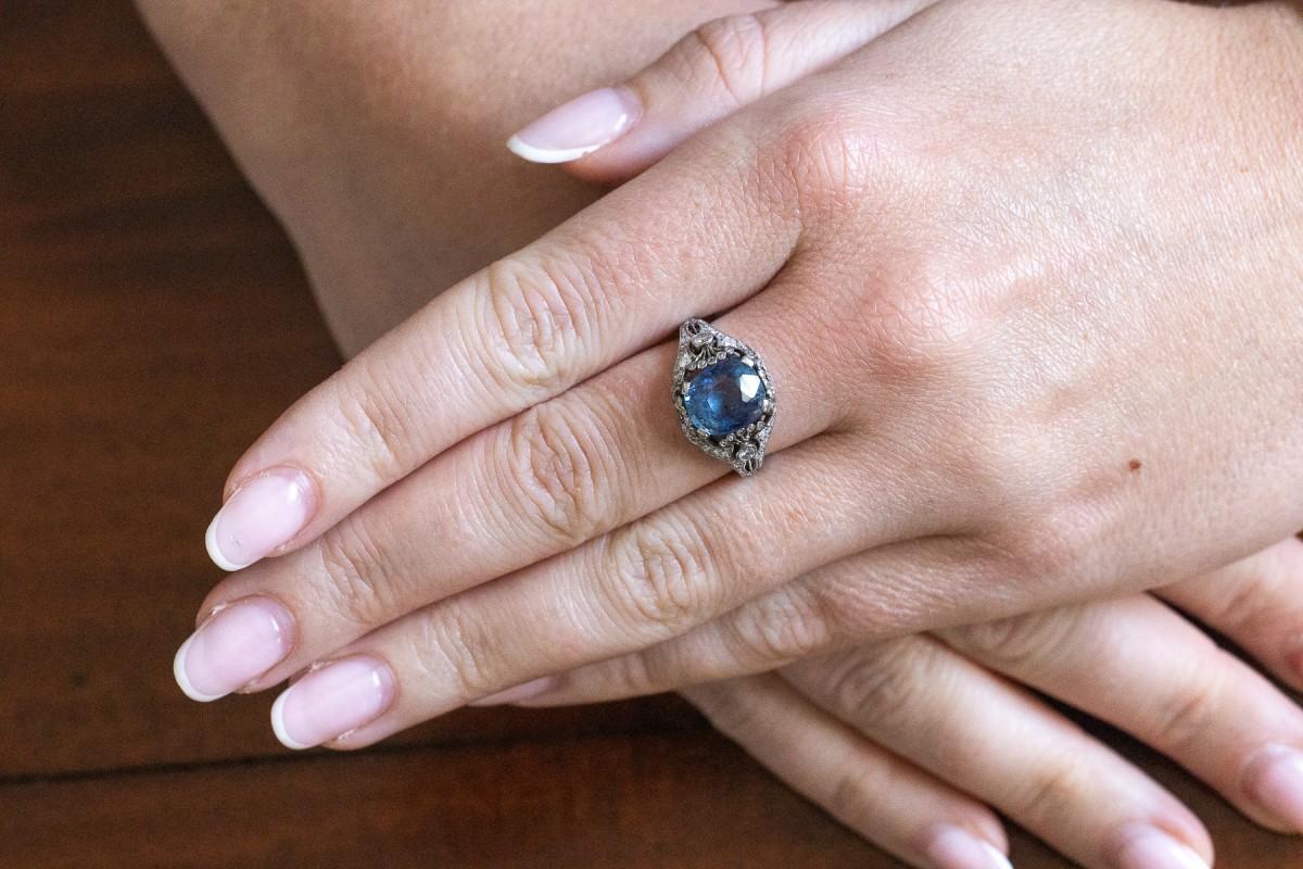 An exclusive ring with an openwork platinum design set with diamonds, centrally set with a natural, unannealed cushion-cut sapphire.

Origin: Sweden, 1930s - hallmark preserved.

This antique ring, with a refined design, centrally set with an