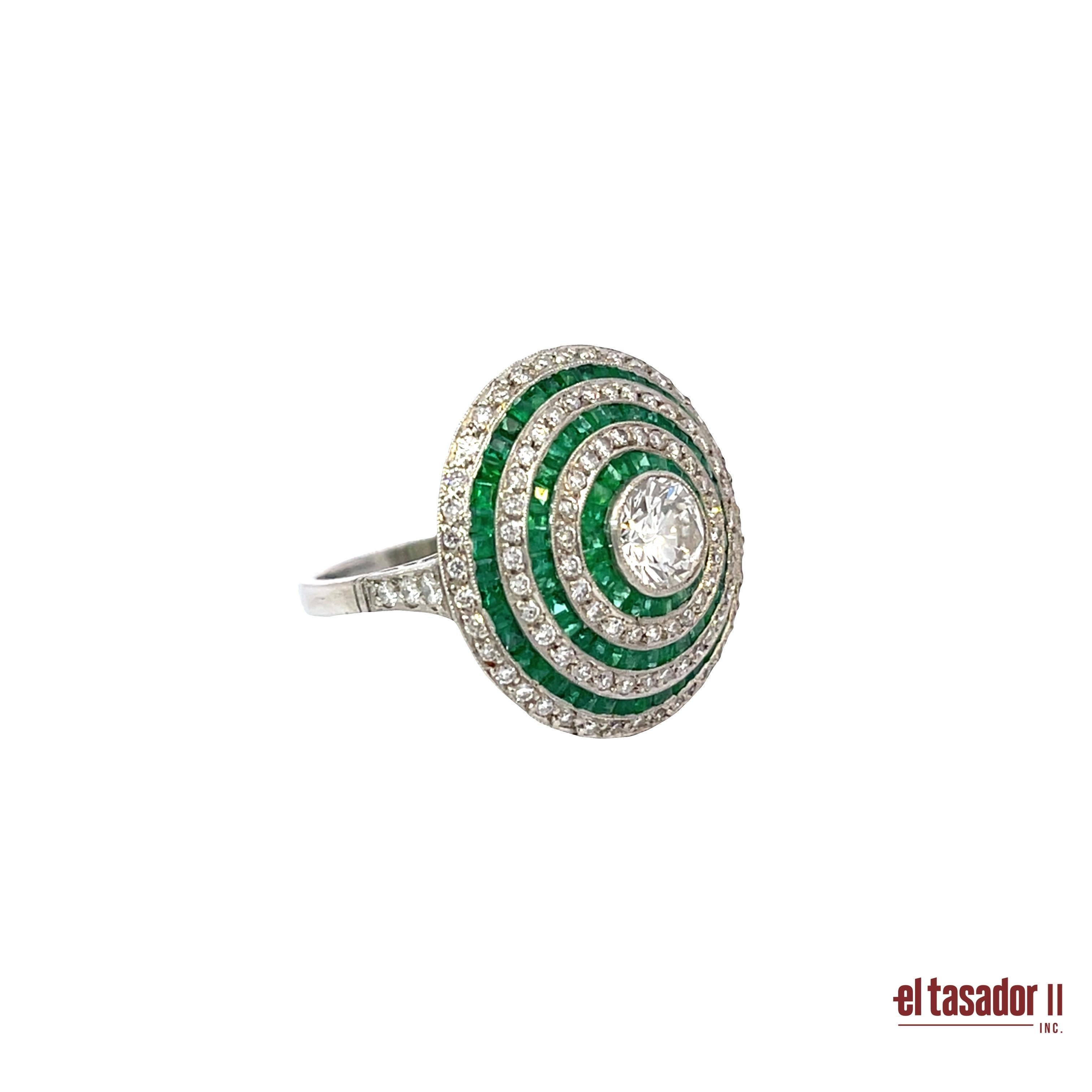 This striking platinum target ring showcases a bold, perfectly symmetrical round design crafted with exceptional precision. At its center rests a brilliant-cut diamond of 0.96 carats, framed by alternating concentric halos of vivid emeralds totaling