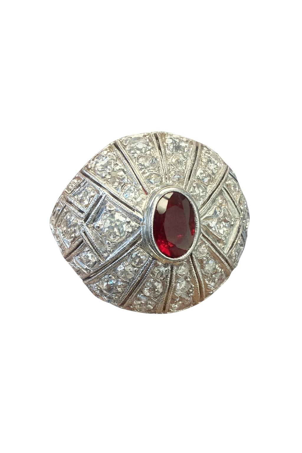 Uno squisito anello a cupola dell'epoca Art Deco realizzato in platino, con al centro un rubino di taglio ovale del peso di circa 0,70 carati. Intorno al rubino ci sono 50 diamanti antichi di vecchia miniera e di piccolo taglio per un totale di