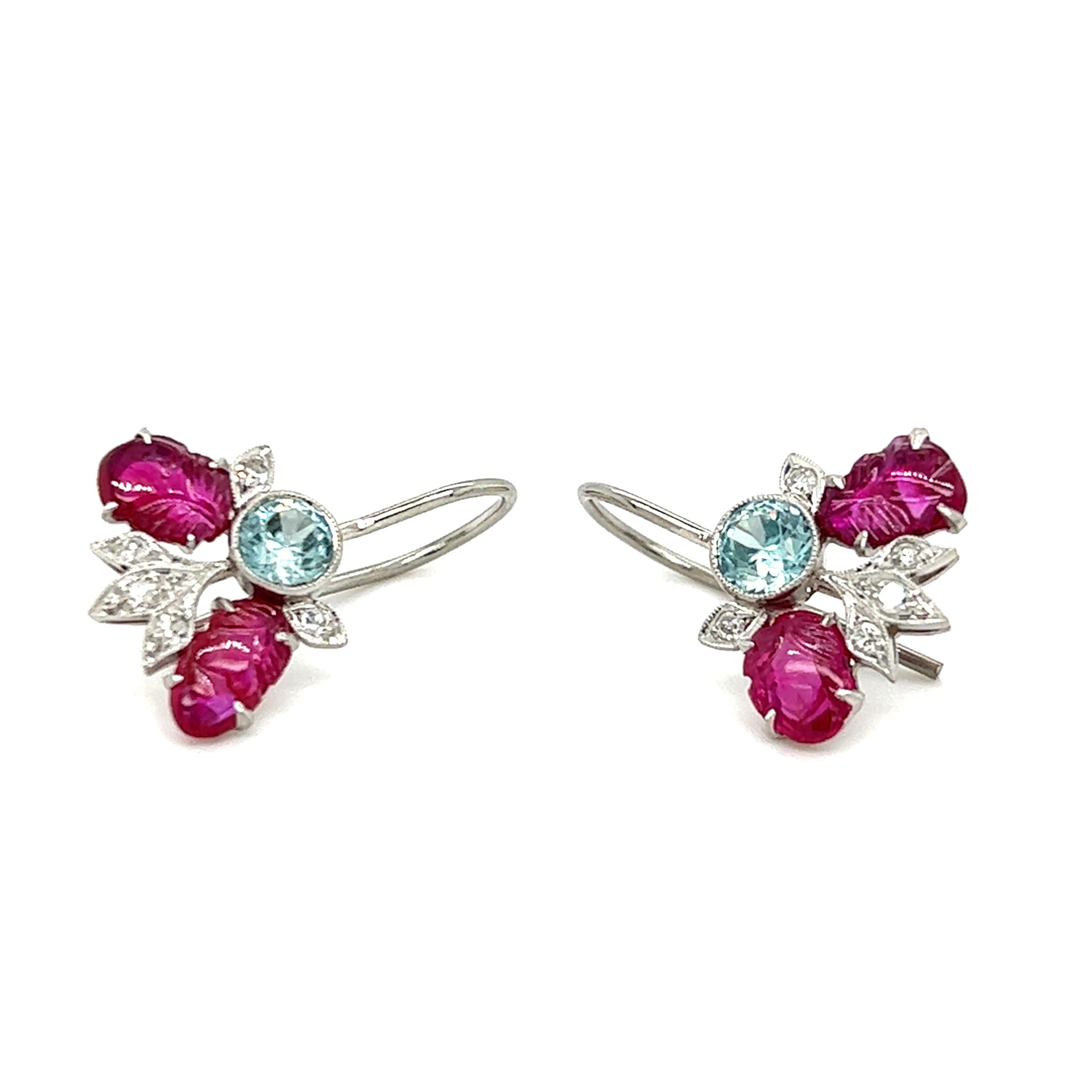One pair of Art Deco platinum earrings, each set with two 6x4mm oval carved rubies, one 4mm round blue zircon and five (5) single cut diamonds, approximately 0.15 carat total weight with matching H/I color and SI1 clarity.  The earrings measure