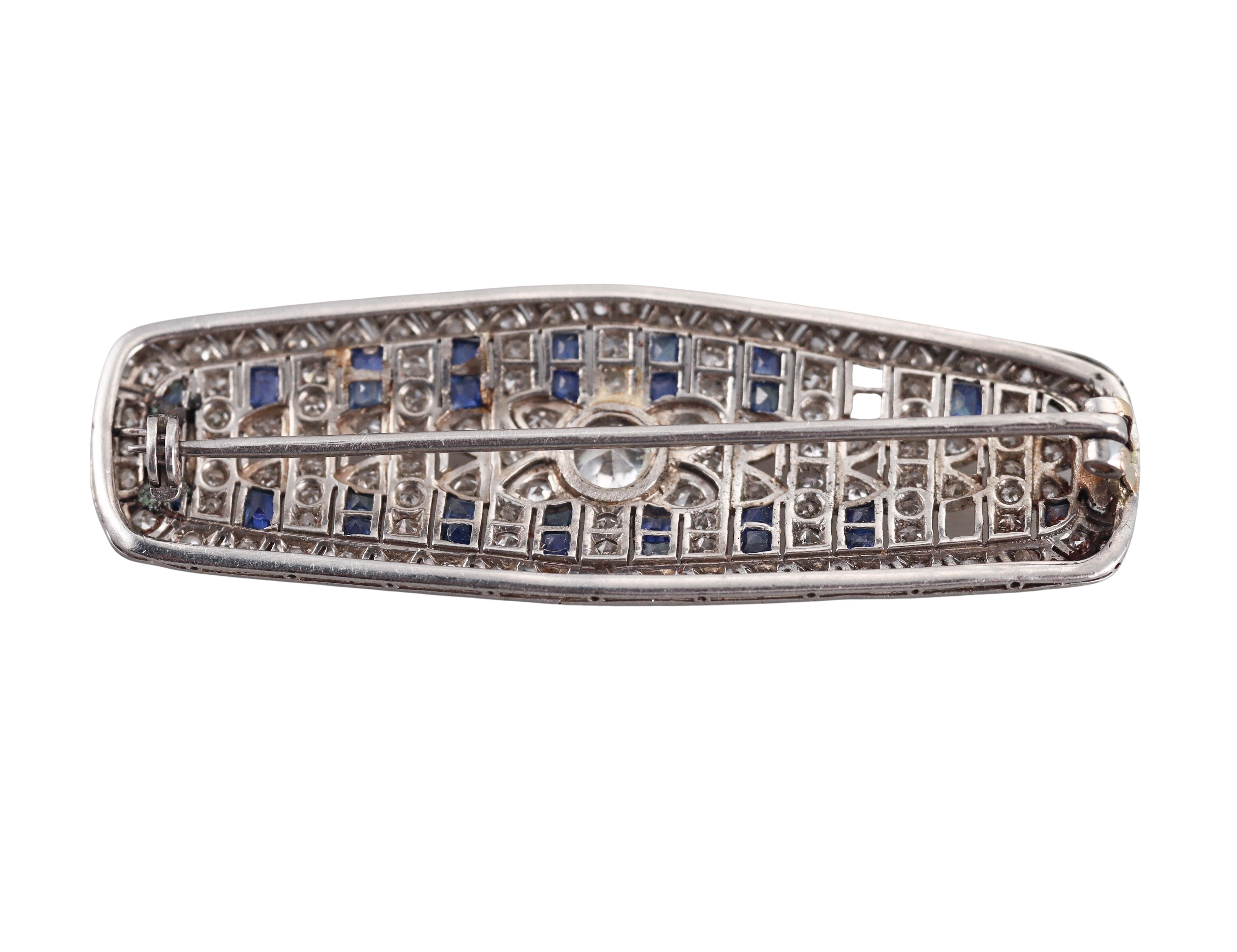 An Art Deco platinum brooch, with blue sapphires and approx. 1.50ctw diamonds  - center stone is approx. 0.65ct SI/I. Few small diamonds and sapphires are missing.
Brooch is 55mm x 19mm.
Tested plat, not marked.
Weight - 12.2 grams. 