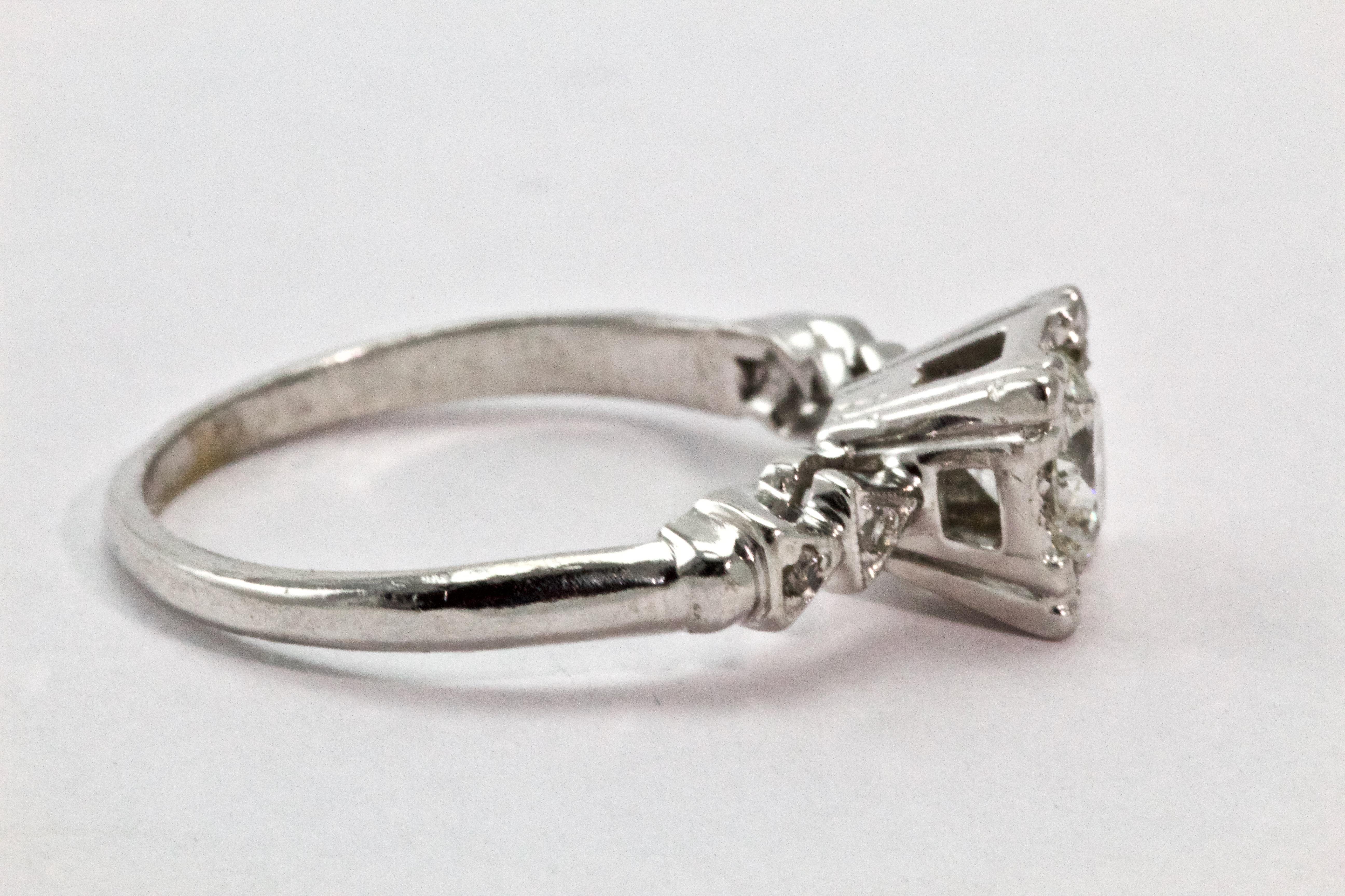 This a perfect example of a stunning Art Deco platinum and diamond solitaire ring. The central old mine cut diamond is beautifully complimented by 'arrow head' diamond shoulders. Total diamond weight certified 82 points, I colour and SI-2