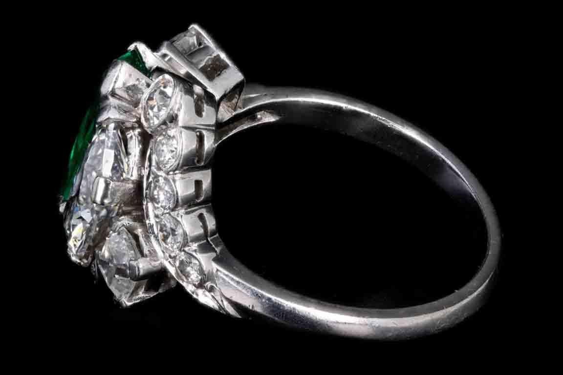 Art deco platinum triangular cut Colombian emerald & half moon cut diamond ring

Era: Art Deco
Composition: Platinum 
Primary stone: AGL Certified Modified Triangular cut Colombian emerald 
Primary stone carat: Approximately 2 carats 
Accent stone: