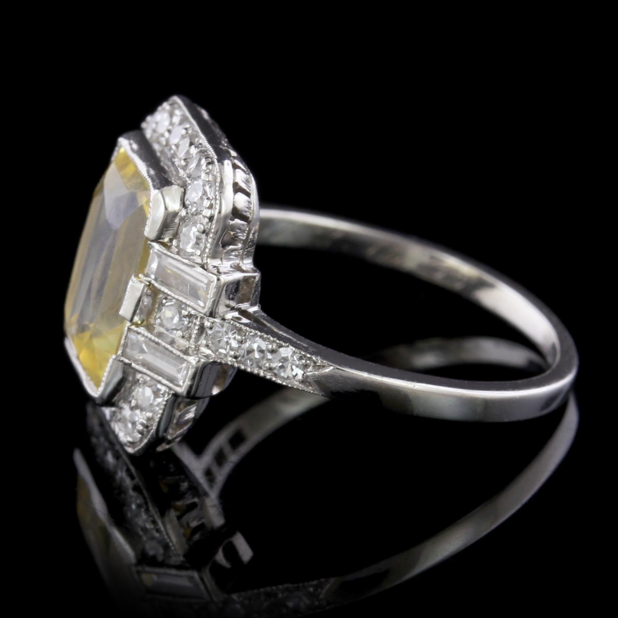 Art Deco Platinum Yellow Sapphire and Diamond Ring. The ring is set with an emerald cut yellow sapphire weighing 3.90cts. actual weight, further set with 24 single cut and four baguette cut diamonds, approx. total wt. .44cts., H color, SI clarity,