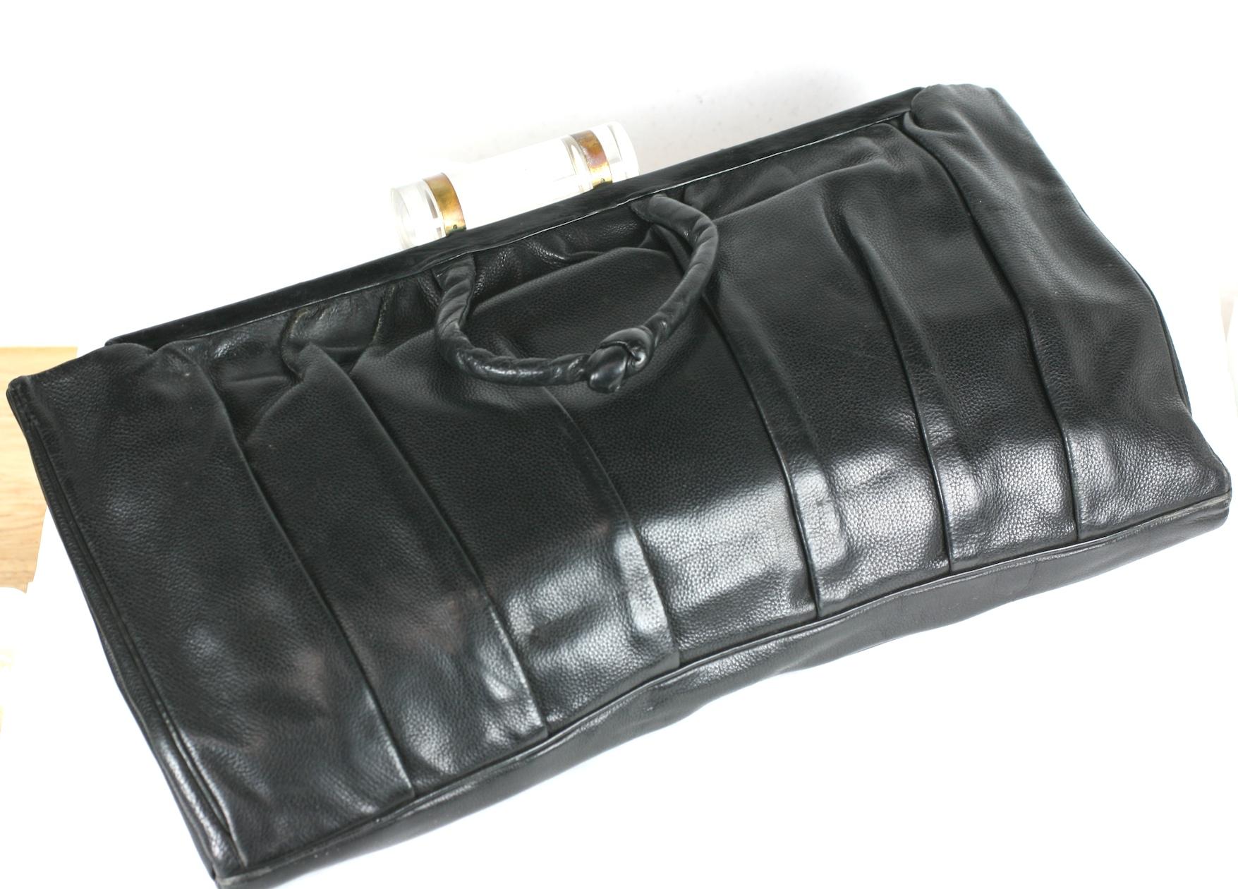 Pochette Art Déco en cuir noir plissé avec fermoir à bascule en lucite. Grande échelle avec mini poignées nouées. Le corps est plissé verticalement. Grande échelle froide. Doublure en satin.  USA des années 30. 
14