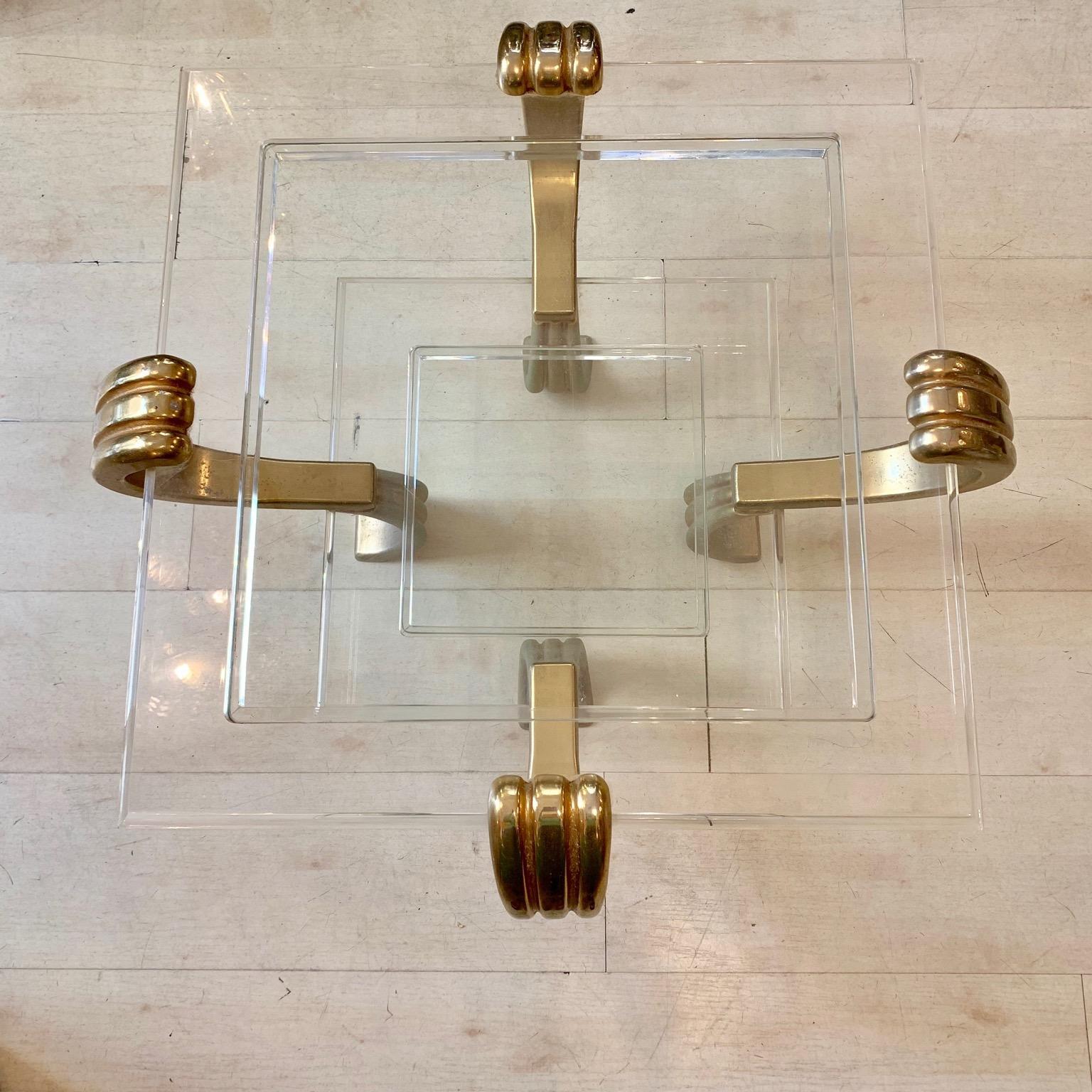 Art Deco plexiglass and brass coffee table, the structure is made of plexiglass, the two shelves are in clear glass. The decorative supports are in golden brass.
The brass has its original patina and presents signs of age and use.