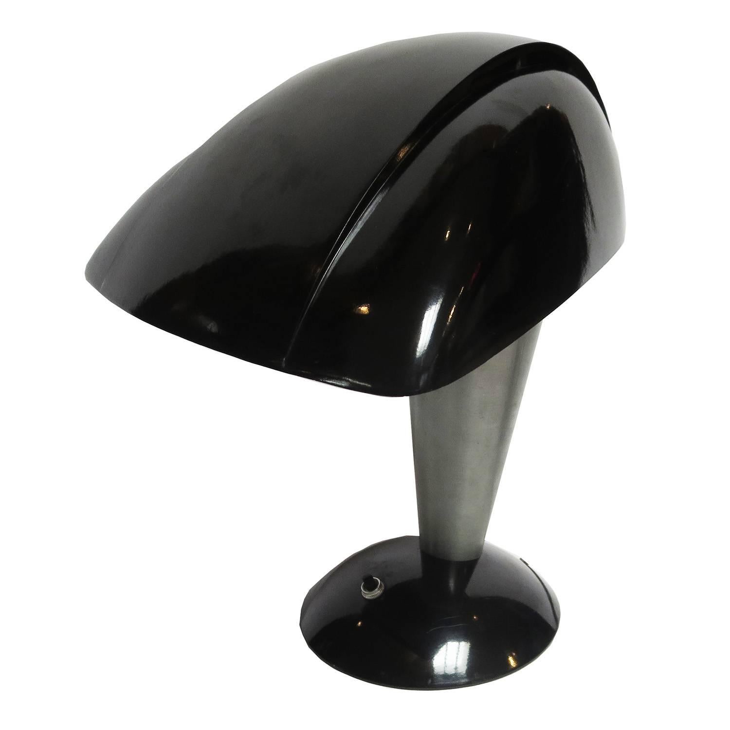 One of the true icons of 20th century design! Designed by Teague for the Polaroid Corporation in 1939, the lamp captures the forward motion of modern design of the 1930's Art Deco movement. Our lamp is a high polished black bakelite, unlike the more