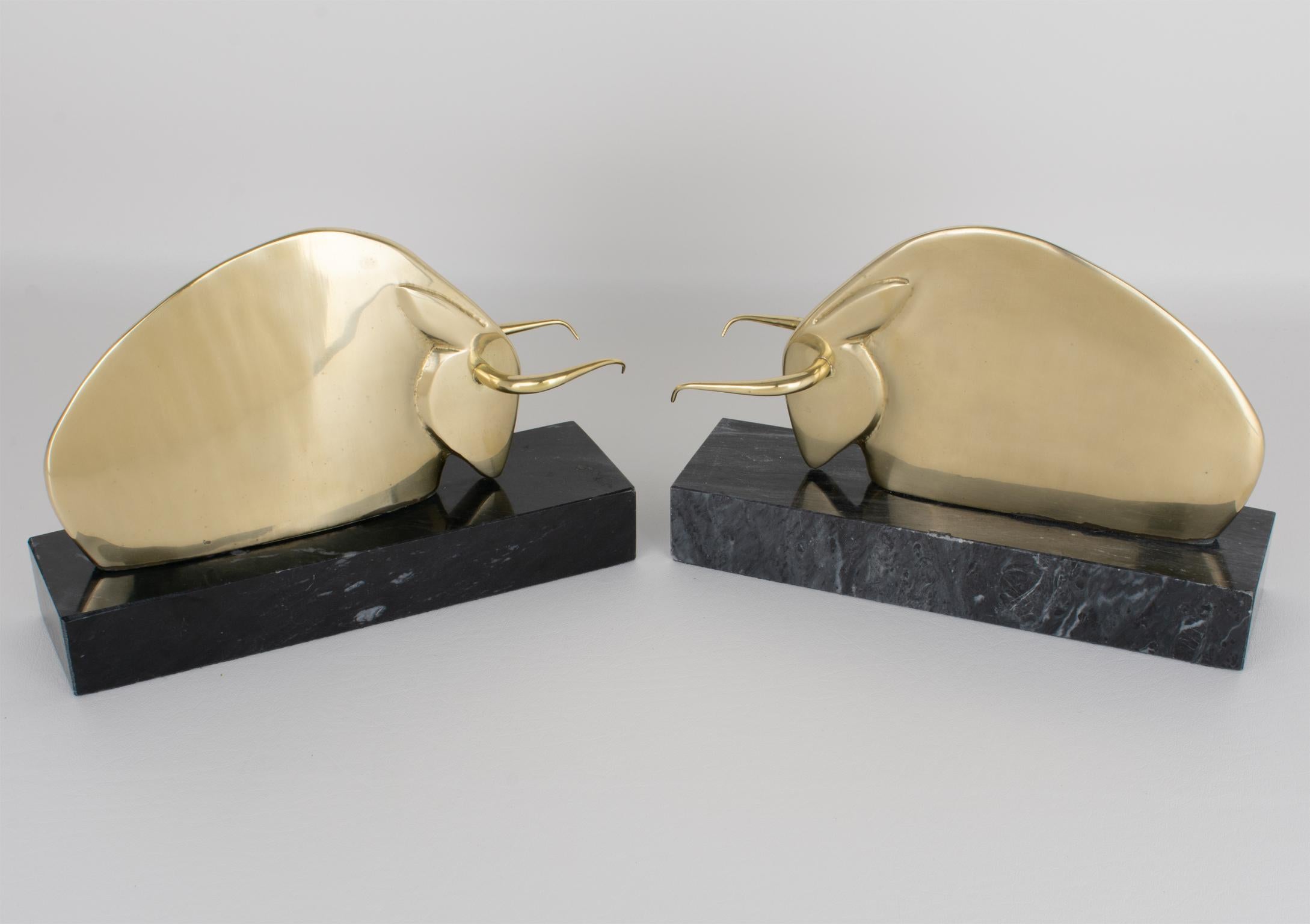 Questa splendida coppia di fermalibri Art Déco è stata realizzata negli Stati Uniti intorno al 1940. Questo raro set è caratterizzato dal disegno di un toro longhorn stilizzato in ottone massiccio e lucido, montato su una base geometrica in marmo