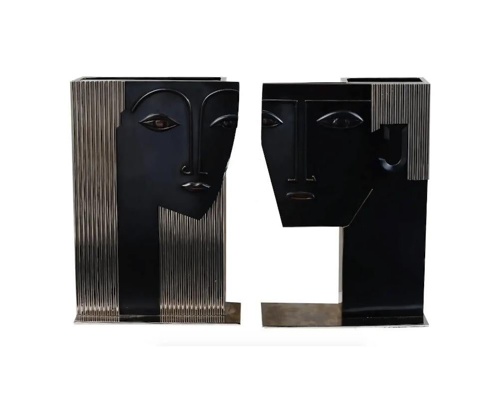 A pair of large Art Deco polished nickel and bronze sculptural vases. The vases depict male and female heads with relief facial features, adorned with a ribbed design. The wares are made in the manner of Franz Hagenauer, Austrian, 1906 to 1986.