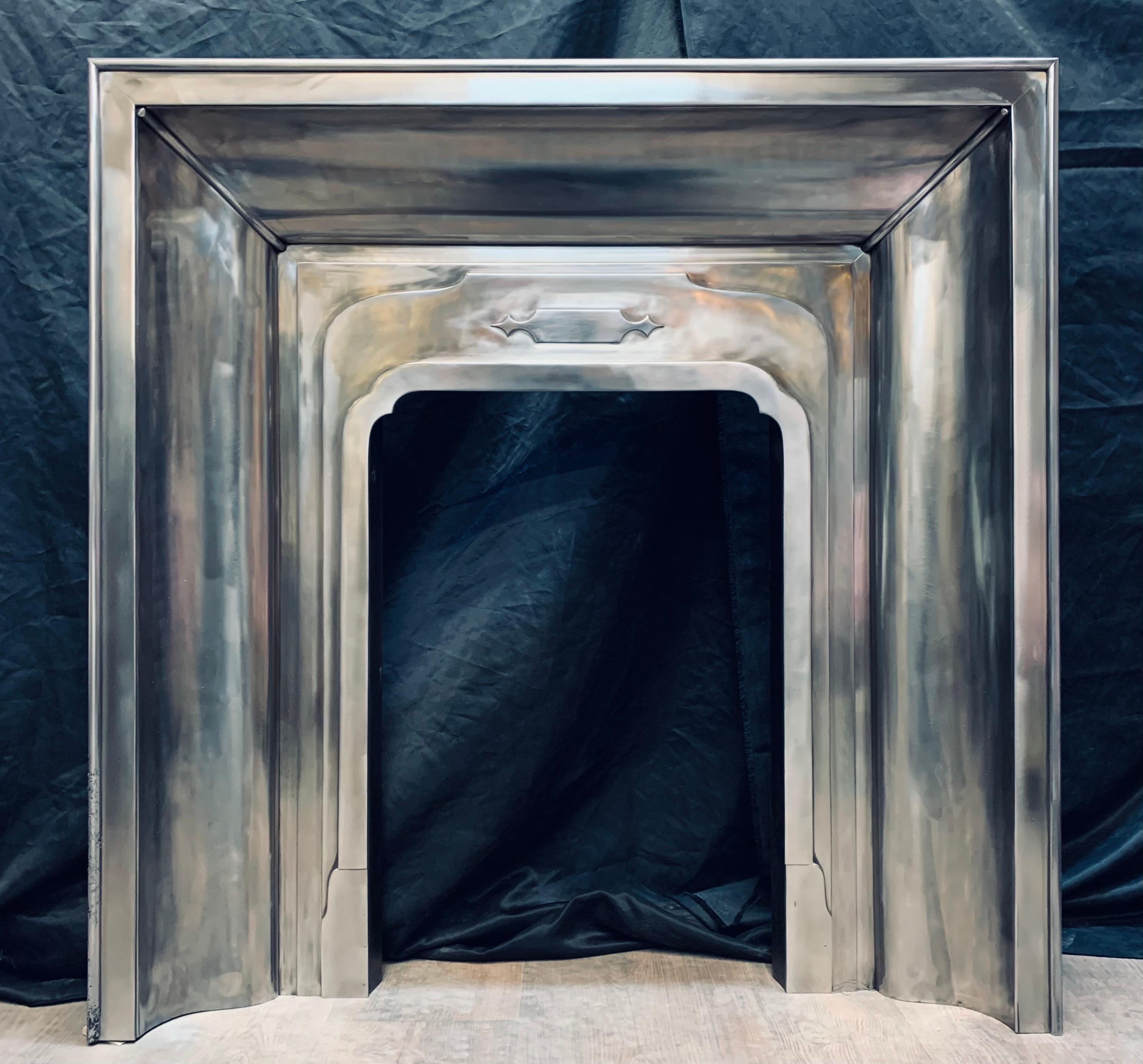 An Art Deco polished register steel fireplace insert, set with a raised moulded edge around an ogee moulded internal Revel, with a central stylized geometric embellishment. 

English circa 1920

Internal fire opening: 455mm wide x 660mm high.