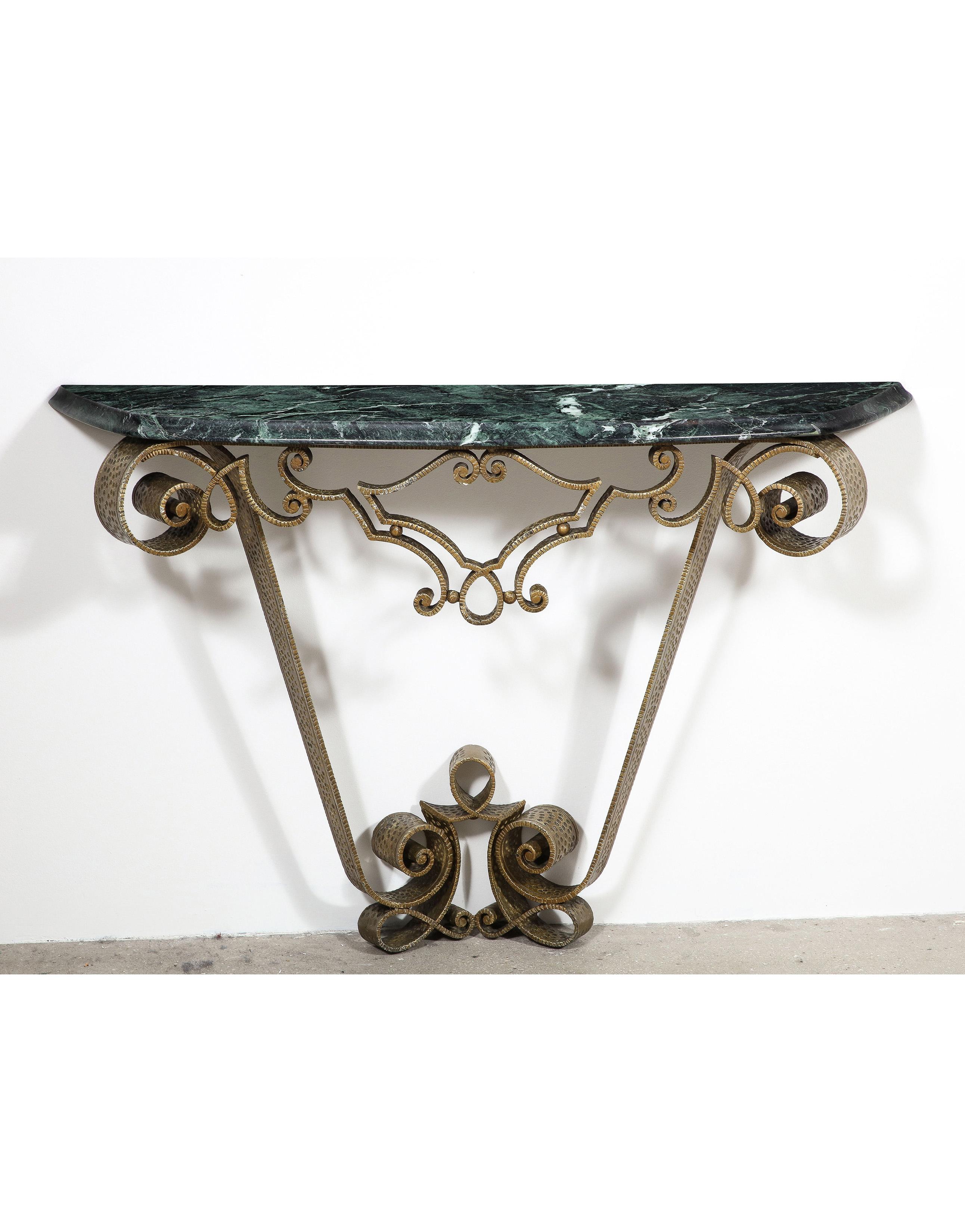 Attributed to Raymond Sube this superbly executed wall mounted scrolling iron console with hammered detailing has an original polychromed finish, the whole supporting a marble top.