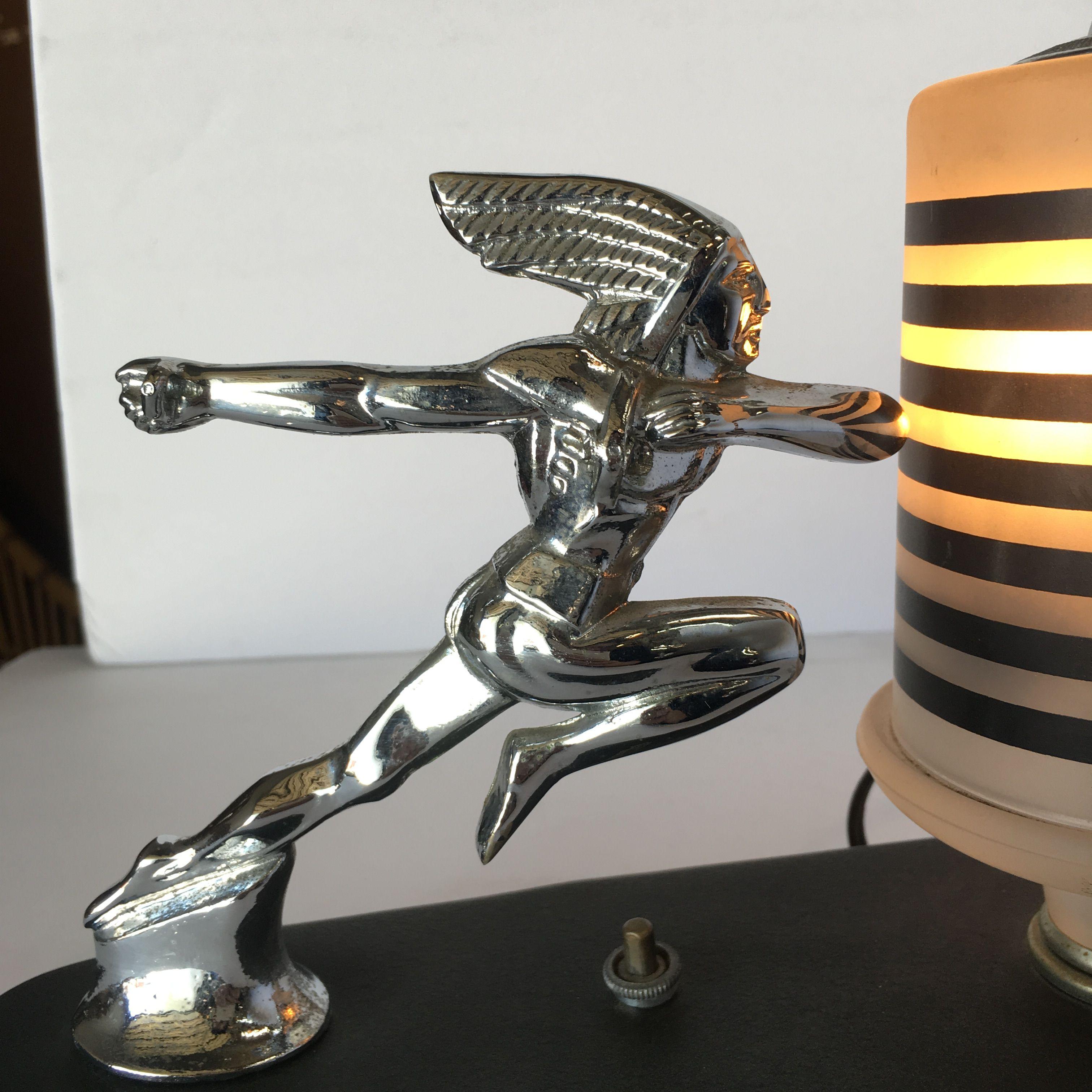Art Deco Style Lamp based on the Pontiac Running Red Indian hood ornament from 1936. In is fixed to a black marble base with a frosted glass bell shaped lamp. Circa 1980.