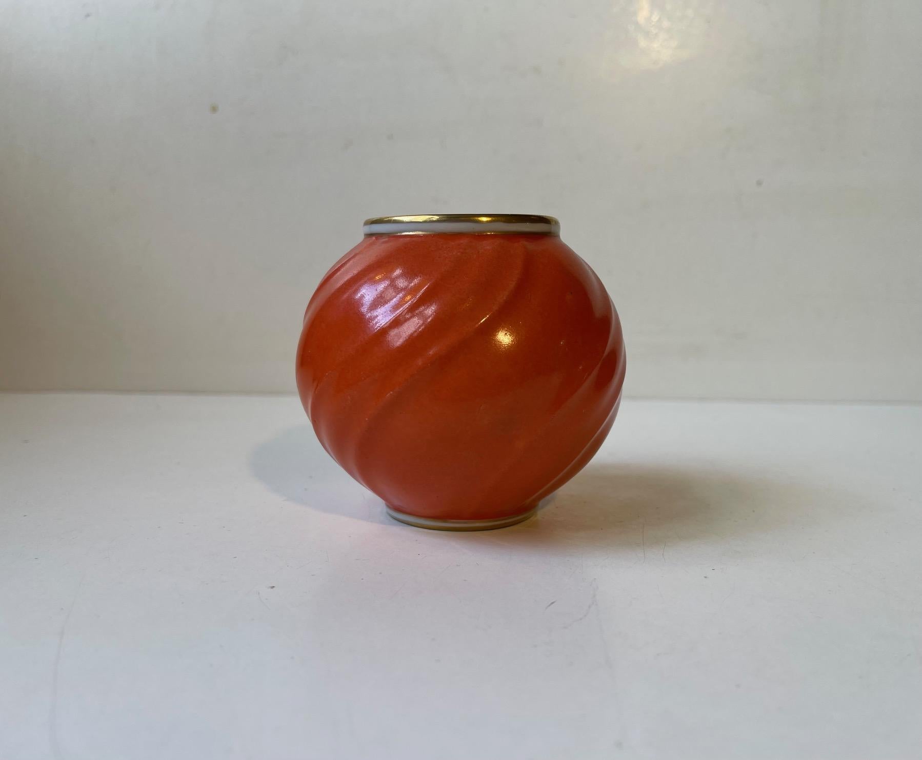Korallenrot/orange glasierte kugelförmige Porzellanvase mit Wirbeln. Hergestellt und entworfen von Lyngby Porcelæn in Dänemark in den 1930er Jahren. Vollständig auf dem Sockel markiert. Abmessungen: H: 8,5 cm, T: 9 cm.