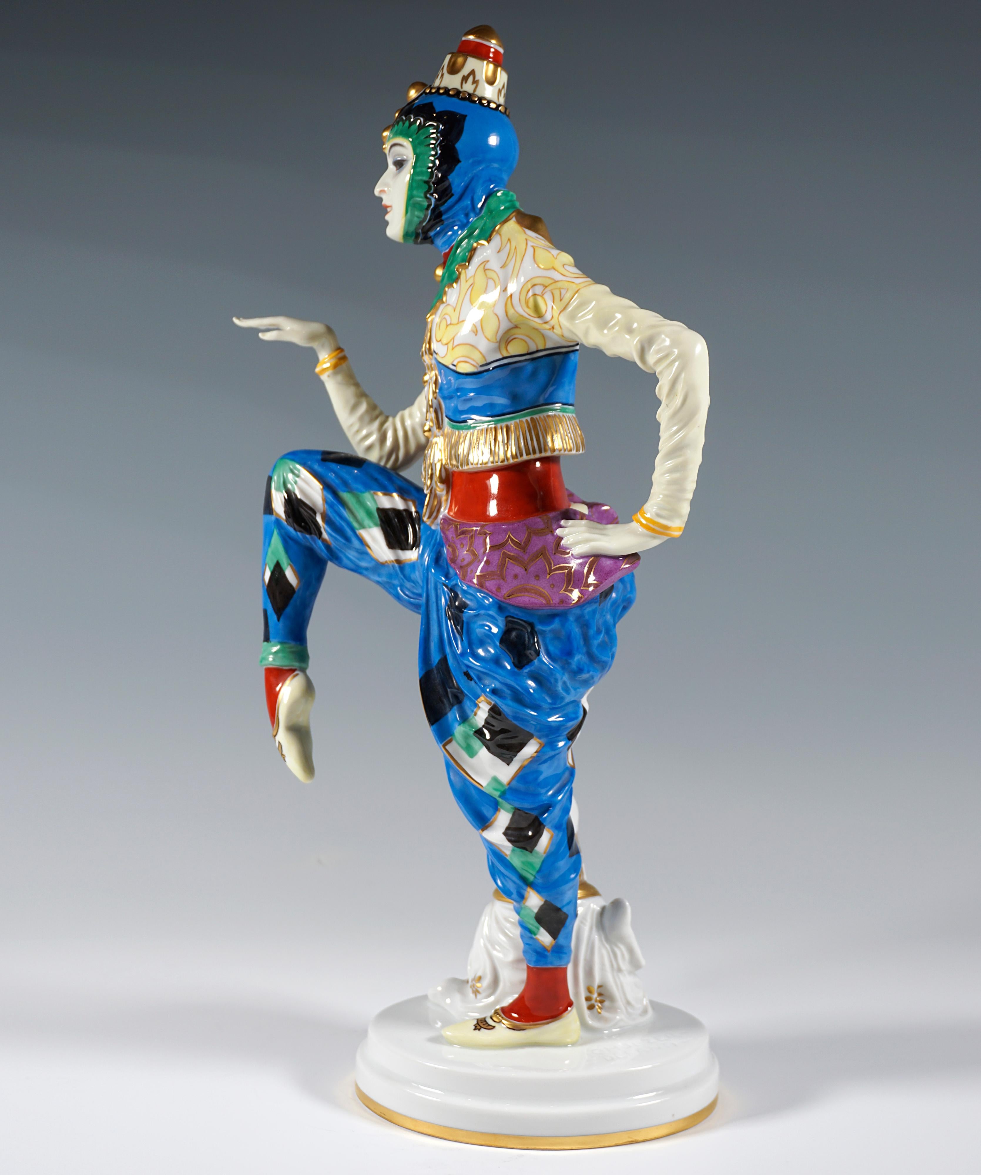 Tänzerin in orientalischem Kostüm mit traditioneller koreanisch anmutender Kopfbedeckung, mit erhobenen, angewinkelten Beinen und Armen in Tanzpose, eine chinesische Pagode an ihr Bein gelehnt. Die Figur ist reich in leuchtenden Farben und Gold