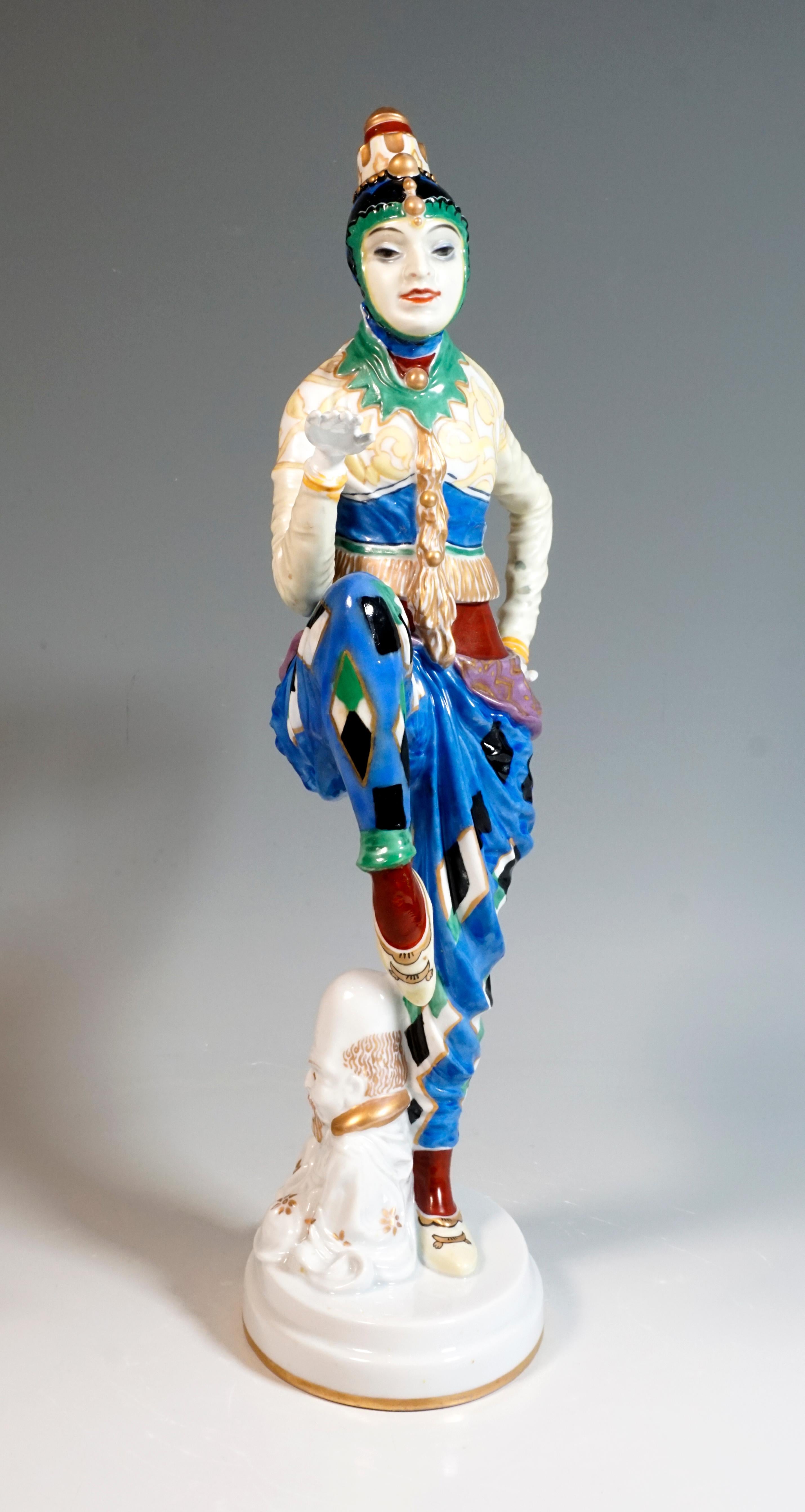 Dancer in an oriental costume with traditional Korean headgear, with raised, bent legs and arms performing a dance pose, a Chinese pagoda leaning against her leg. The figure is richly painted in bright colors and gold and is based on a white,