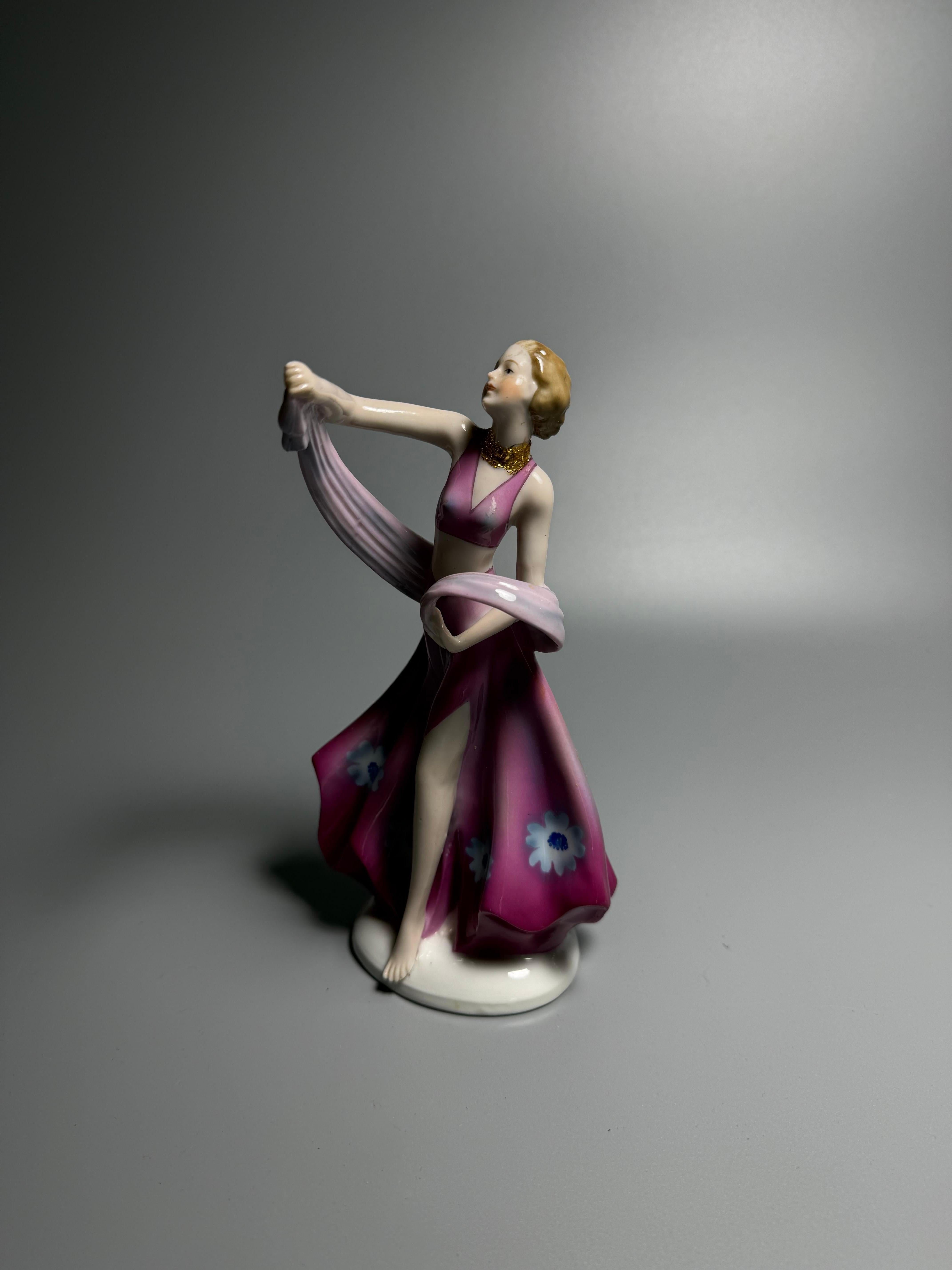 Si tratta di una statuetta di ballerina in porcellana Art Deco, probabilmente prodotta da FASOLD & STAUCH. 
1940-1950

FASOLD & STAUCH era una fabbrica di porcellana tedesca nota per le sue statuette in stile Art Déco. 

La figura raffigura una