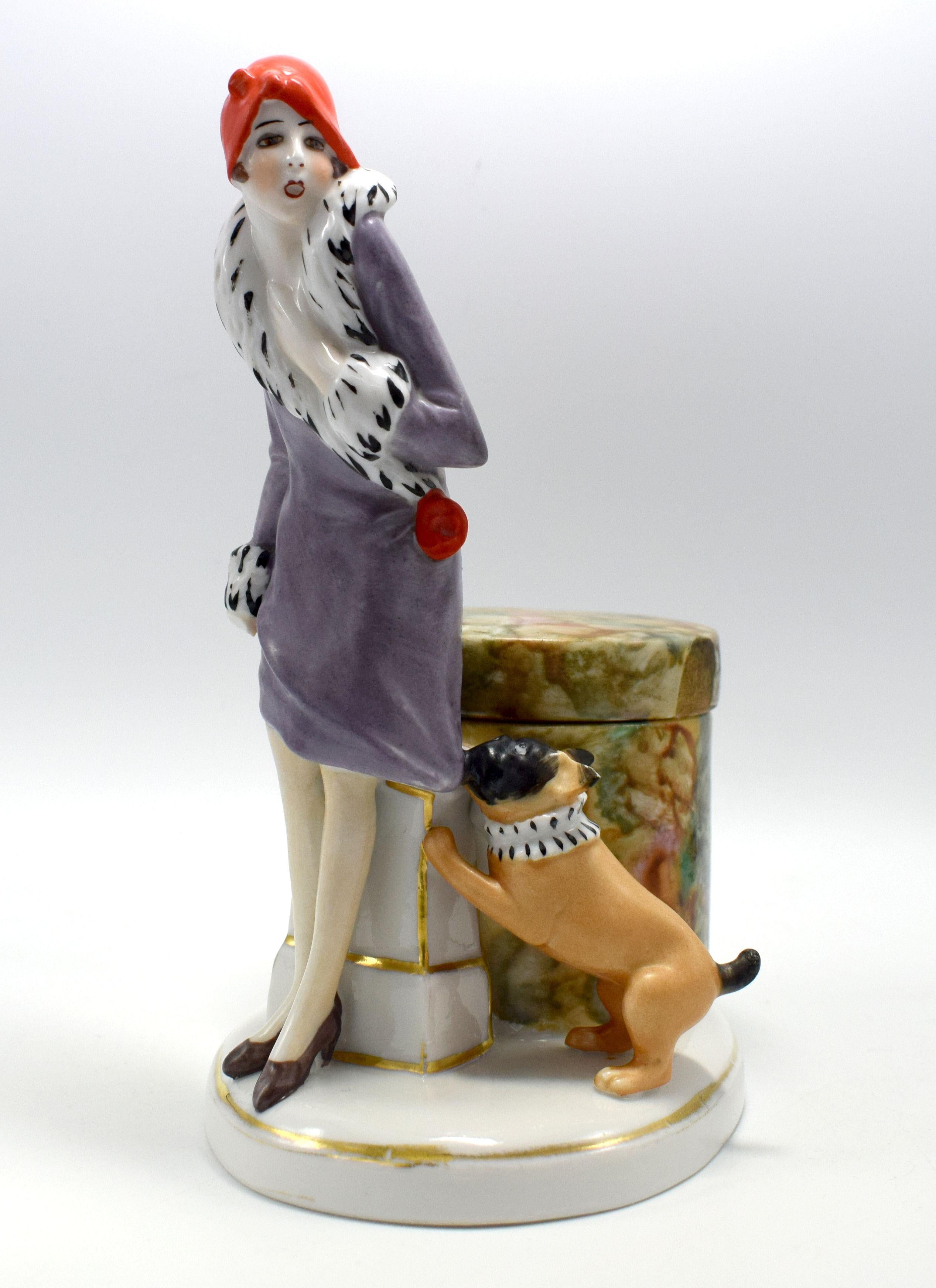 For your consideration is this rare and very enchanting porcelain powder / trinket box, dating to the 1930s , sourced in France. Depicts a flapper girl stood with her companion dog which is tugging on her coat. She's dressed in the fashion of the