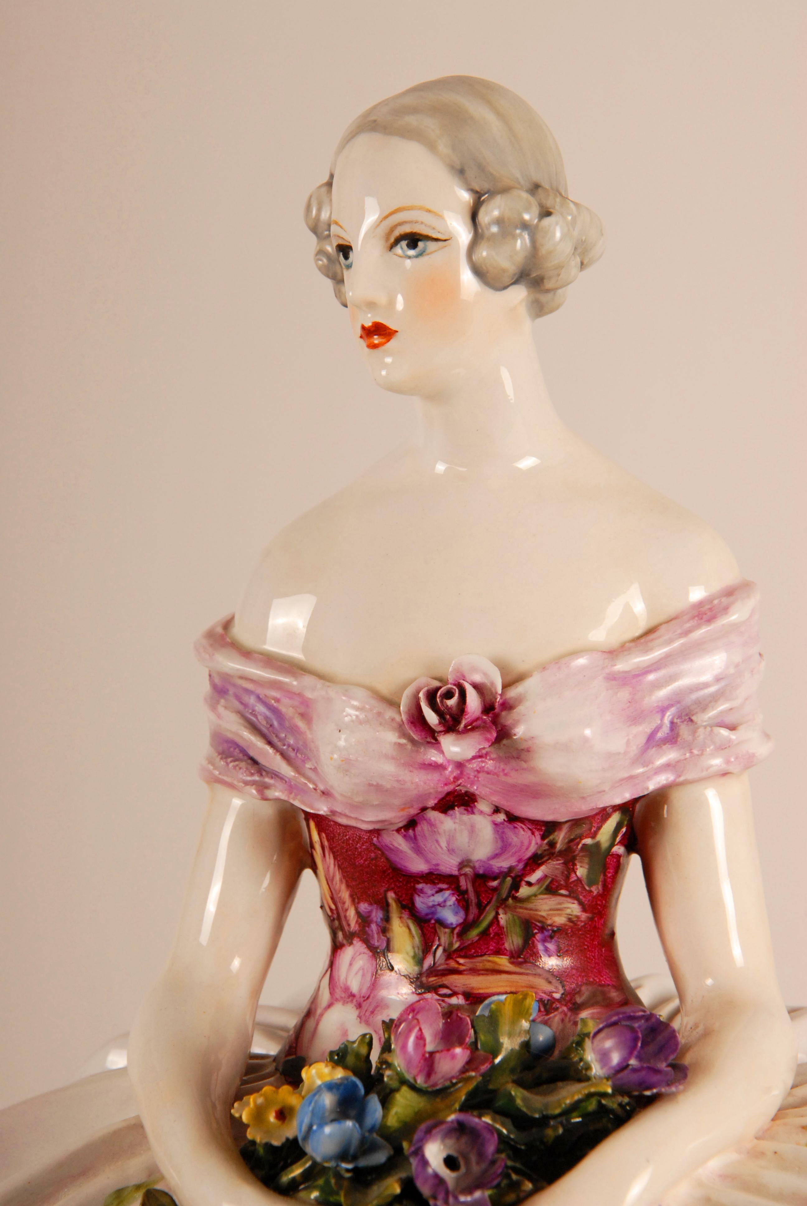Art Deco large porcelain lady figurine Italian sculpture..
Handmade ceramic figurative sculpture by Guido Cacciapuoti.
Depicting a lady in a ball gown dress seated on a Rococo style bench.
Her pink dress heighten with gold and embellished with hand