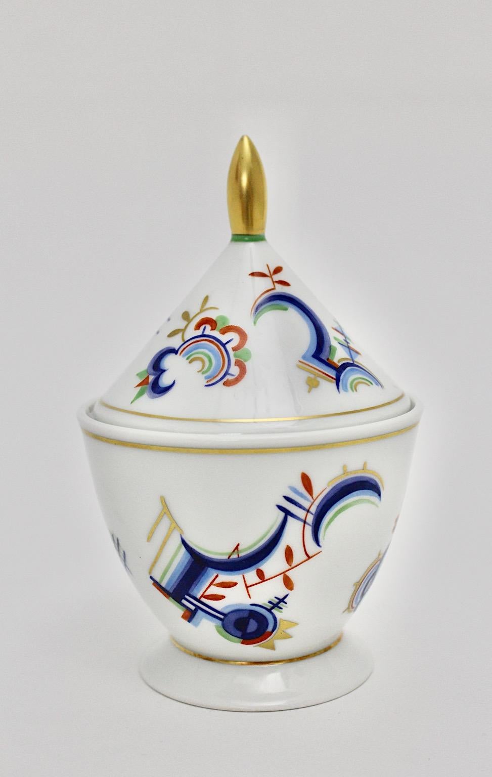 Art Deco Vintage multicolored porcelain lid box by Rosenthal Selb Bavaria Schwalb circa 1939 Germany.
A graceful hand painted Art Deco lid box from porcelain by Rosenthal Selb Bavaria with multicolored Art Deco elements in blue, red and gold