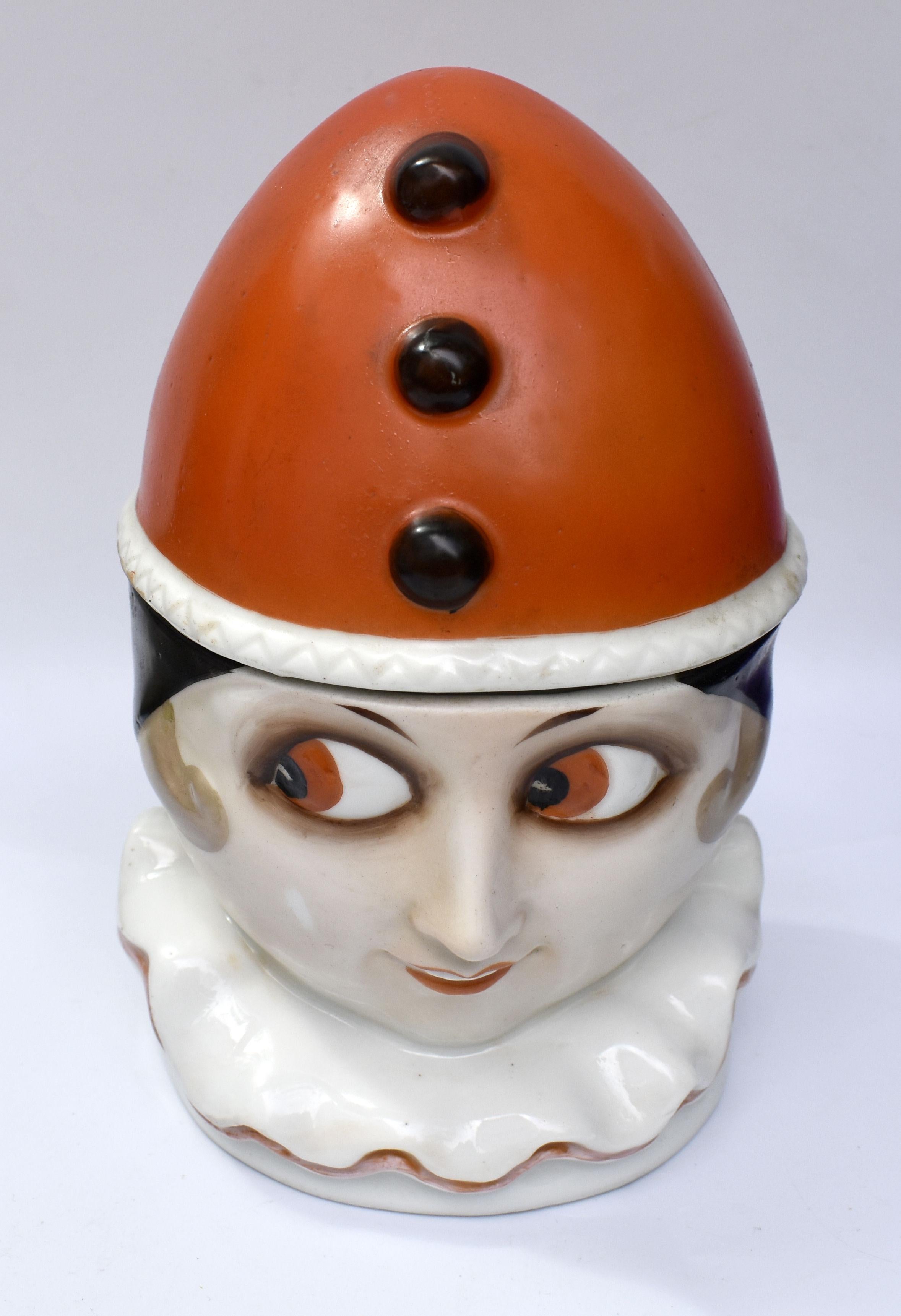 Beautifully styled is this 1930's Art Deco porcelain lidden jar, representing a clown / Pierrot . Typical Art Deco colouring which is as bright and crisp as when first manufactured. The glaze is also free from crazing. Wonderfully styled features .