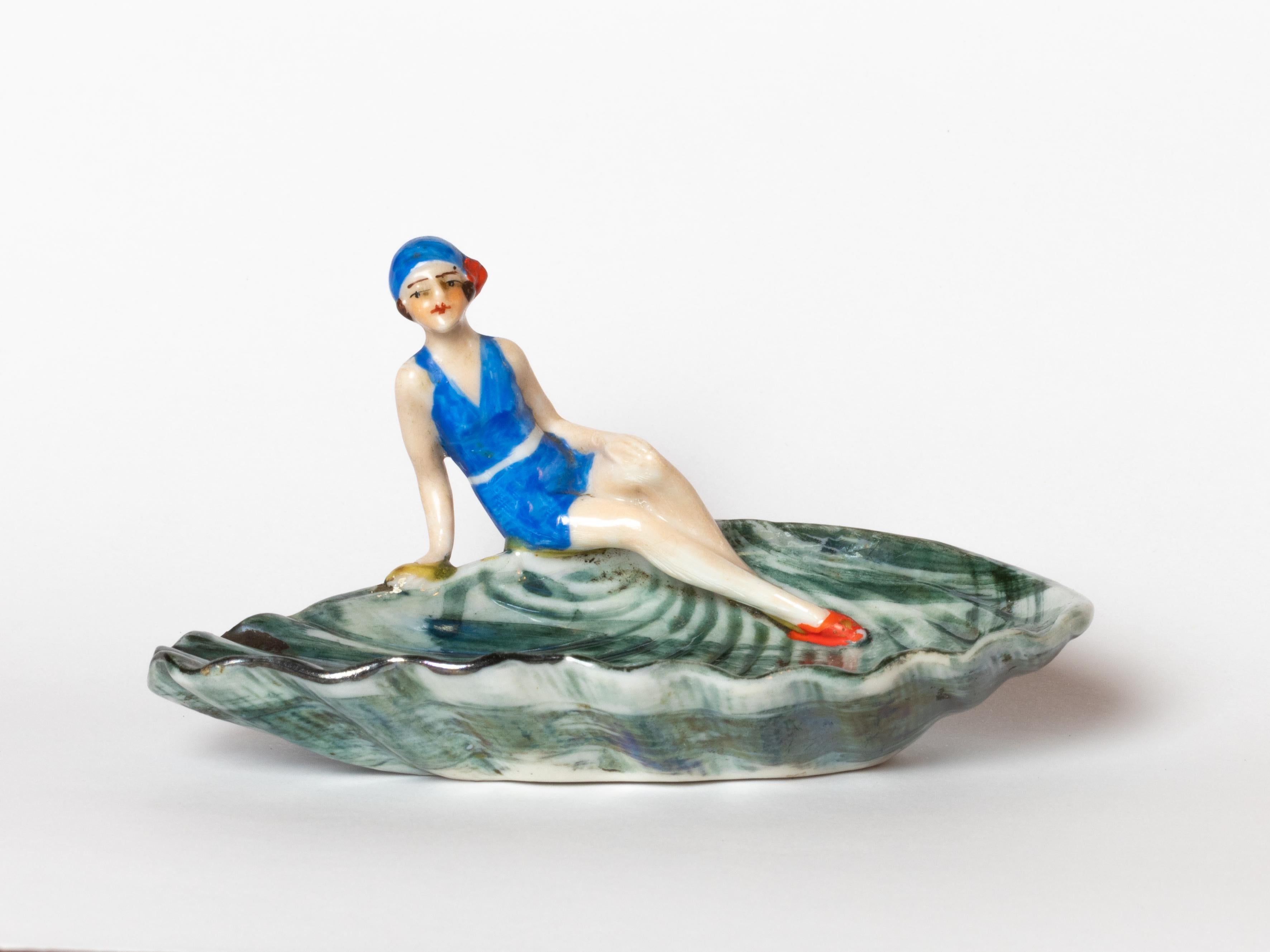 An Art Deco porcelain figurine from 1929, crafted by W. Goebel in Rodental, Bavaria, features a refined pin-up figure with a nacre-like finish.

The miniature sculpture stands out for its delicate modeling and elegant posture, inspired by the iconic