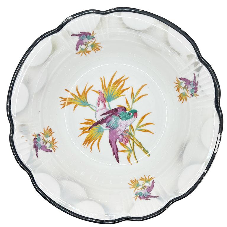 Servierplatte aus Porzellan im Art déco- oder Jugendstilstil mit Papageienmotiv. Diese Servierplatte aus Keramik ist eine farbenfrohe Ergänzung für Ihre nächste Veranstaltung. Die Schale ist rund und in einem strahlenden Weiß gehalten. Die Ränder
