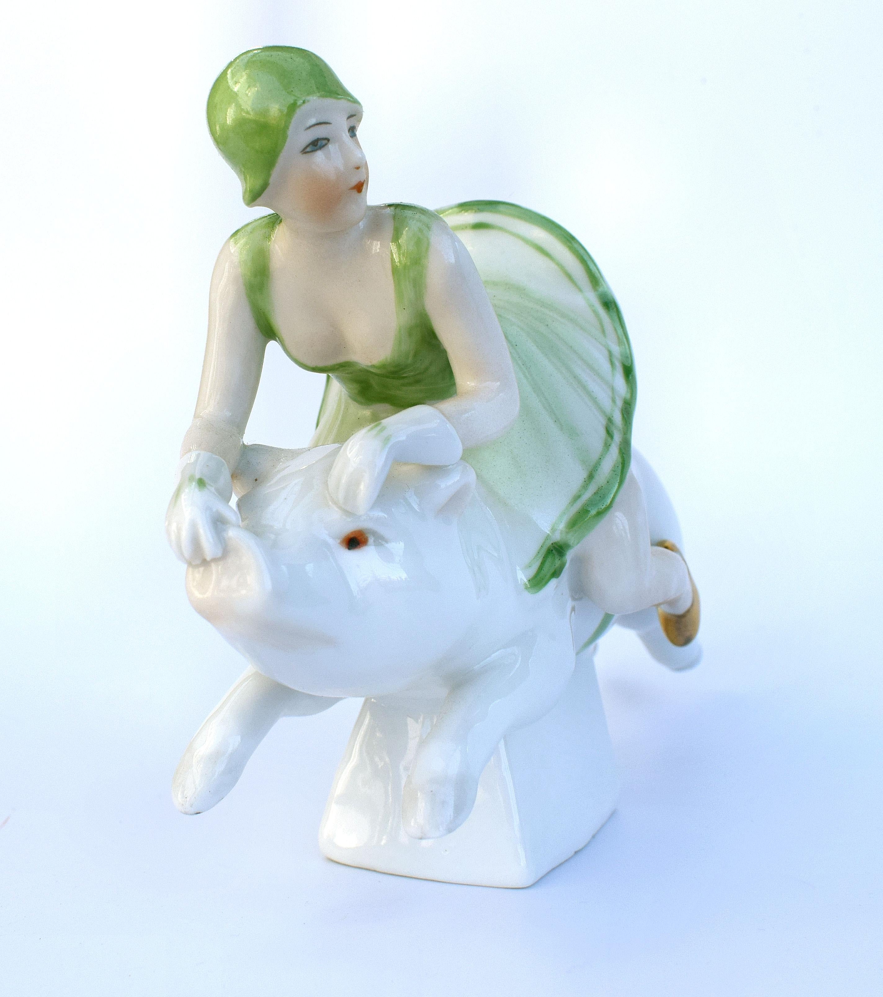 Part of the Half doll family is this novelty pin tray bowl which depicts a 1920's girl in the fashion of the day flying on the back of a pig. The detailing is superb and with humour as she uses the pigs snout as a grip. Lovely colouring pea green