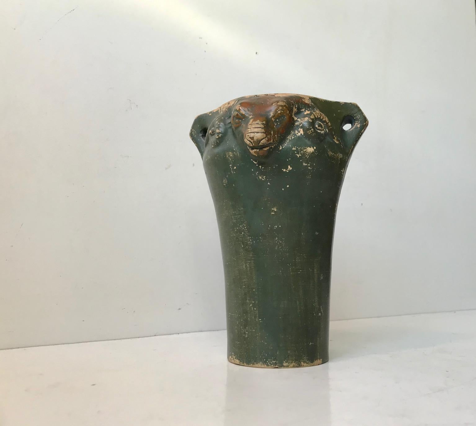 Early 1920s painted pottery vase sculpted with ram heads. Its in the style of Karl Hansen Reistrup and often assumed being made by Michael Andersen and Son. But it was actually made by Knabstrup who were basically neighbors to Kähler in Næstved,