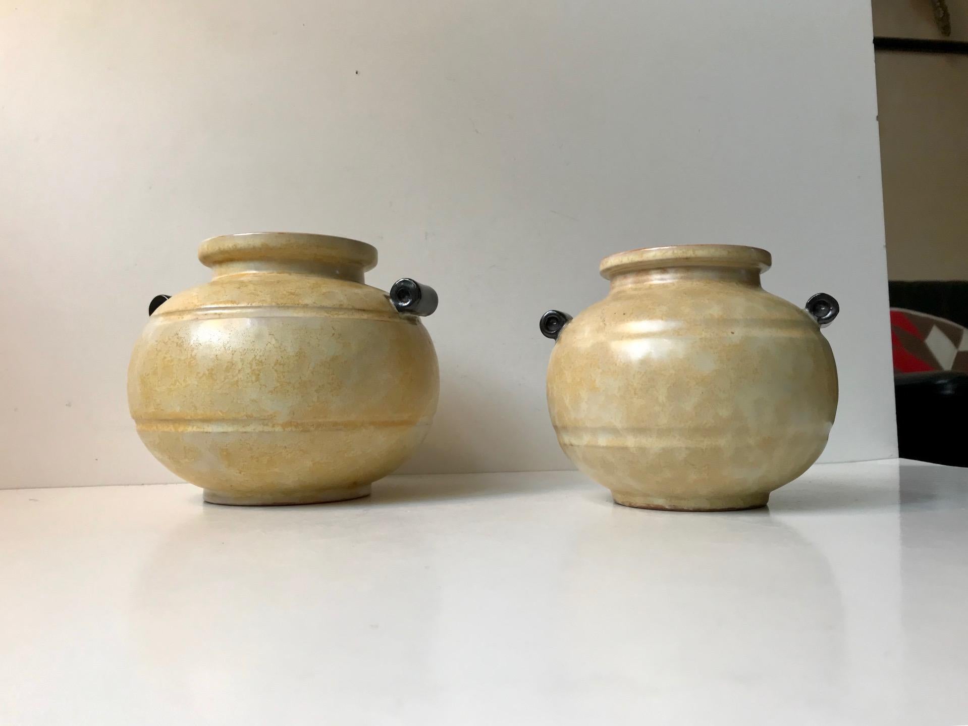 A matching set of handled art deco pottery vases in earthy pastel glazes. Designed by Harald Ostergren and manufactured by Ekeby in Uppsala Sweden during the 1930s. The vases have the model numbers: 2750 and 2751- hence the slight difference in