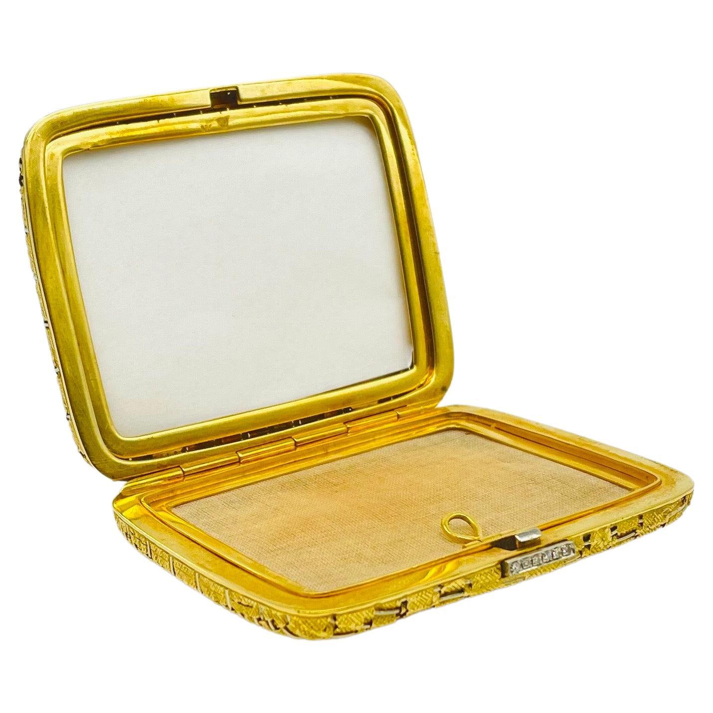 
Immerse yourself in the dreamlike beauty of this exquisite Art Deco powder compact, an opulent masterpiece crafted in 18k yellow gold. Weighing an impressive 129g, this luxurious accessory is a true testament to elegance and sophistication. This