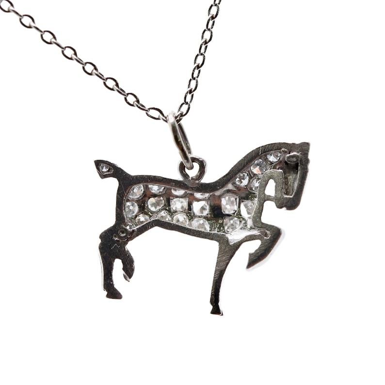 Aston Estate Jewelry Presents:

An Art Deco period diamond horse charm in platinum. Crafted in stunning lifelike detail, down to the face and platinum reins. Pave set throughout with 20 diamonds of 0.39CTW with G color and VS clarity.

Tests as