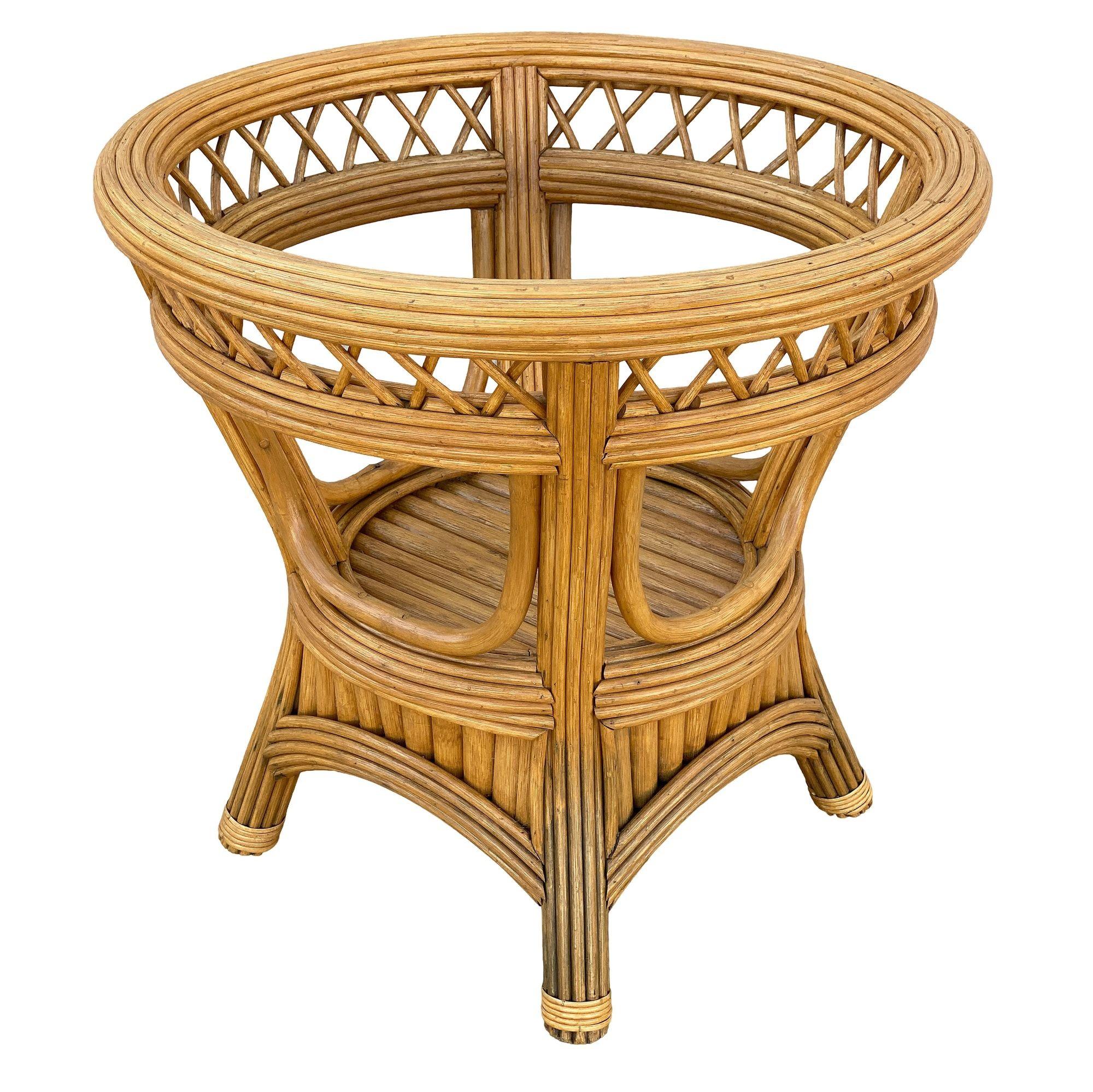 La table de salle à manger Art Deco President en rotin Stick Reed avec plateau en verre présente un design distinctif à double arche, fabriqué en rotin naturel avec des détails complexes en stick reed. La table présente un design en fuseau avec un