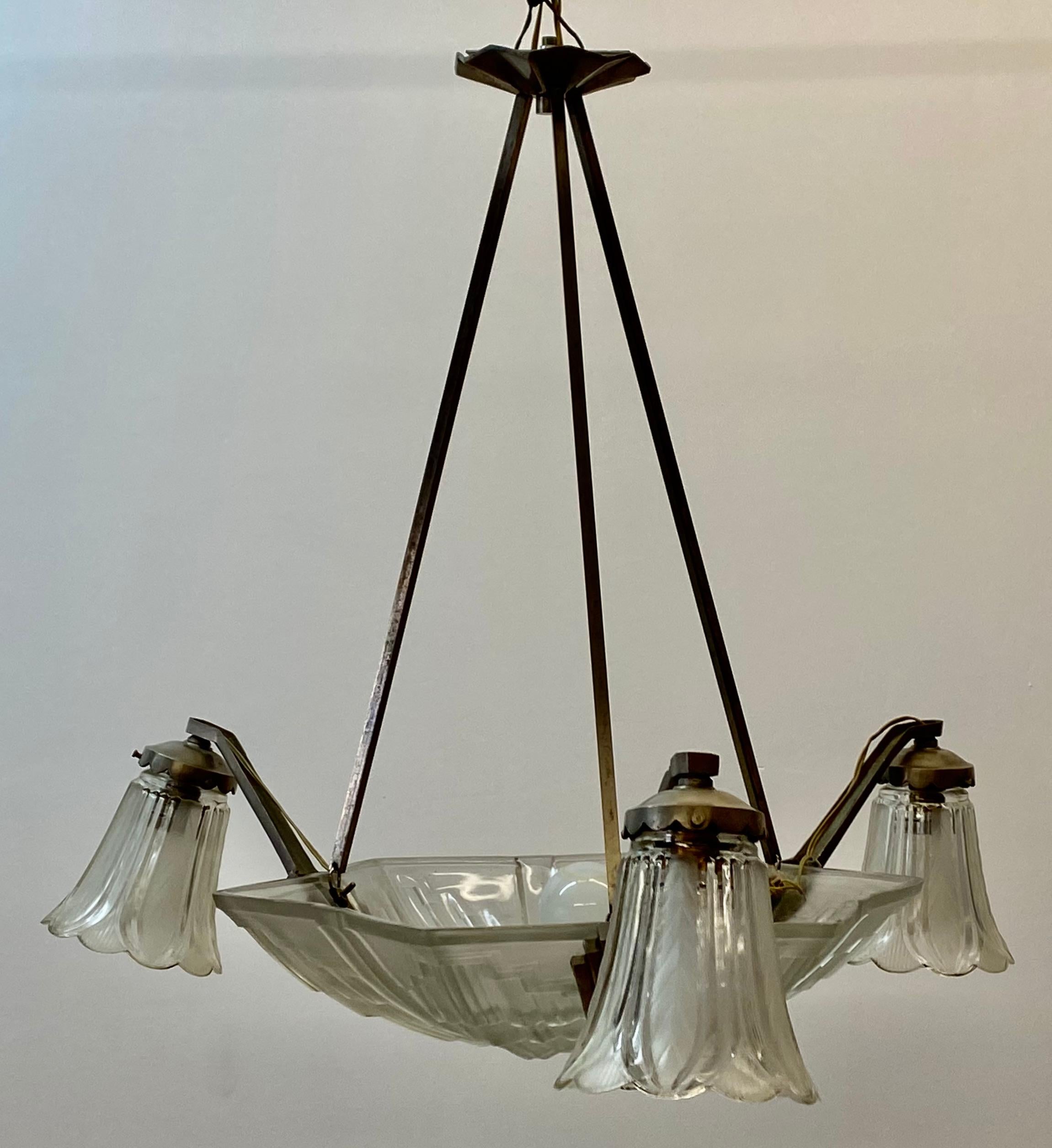 Art Deco pressed glass four light chandelier C.1940

Pressed glass chandelier with three glass flower shades under a pressed glass canopy with a geometric pattern - Classic vintage Art Deco!

The chandelier measures 23