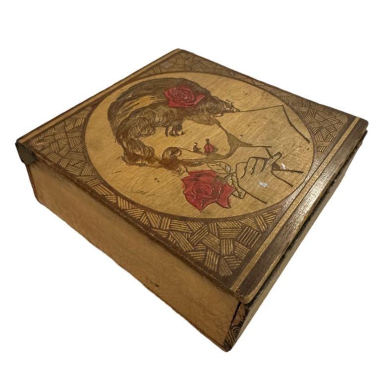 Art Deco pyrography carved cigar box featuring a Little Wonder Girl portrait along the front . The flapper girl is highlighted with a painted red flower in her hair with a geometric pattern framing the portrait.

The 1920s woman, often referred to