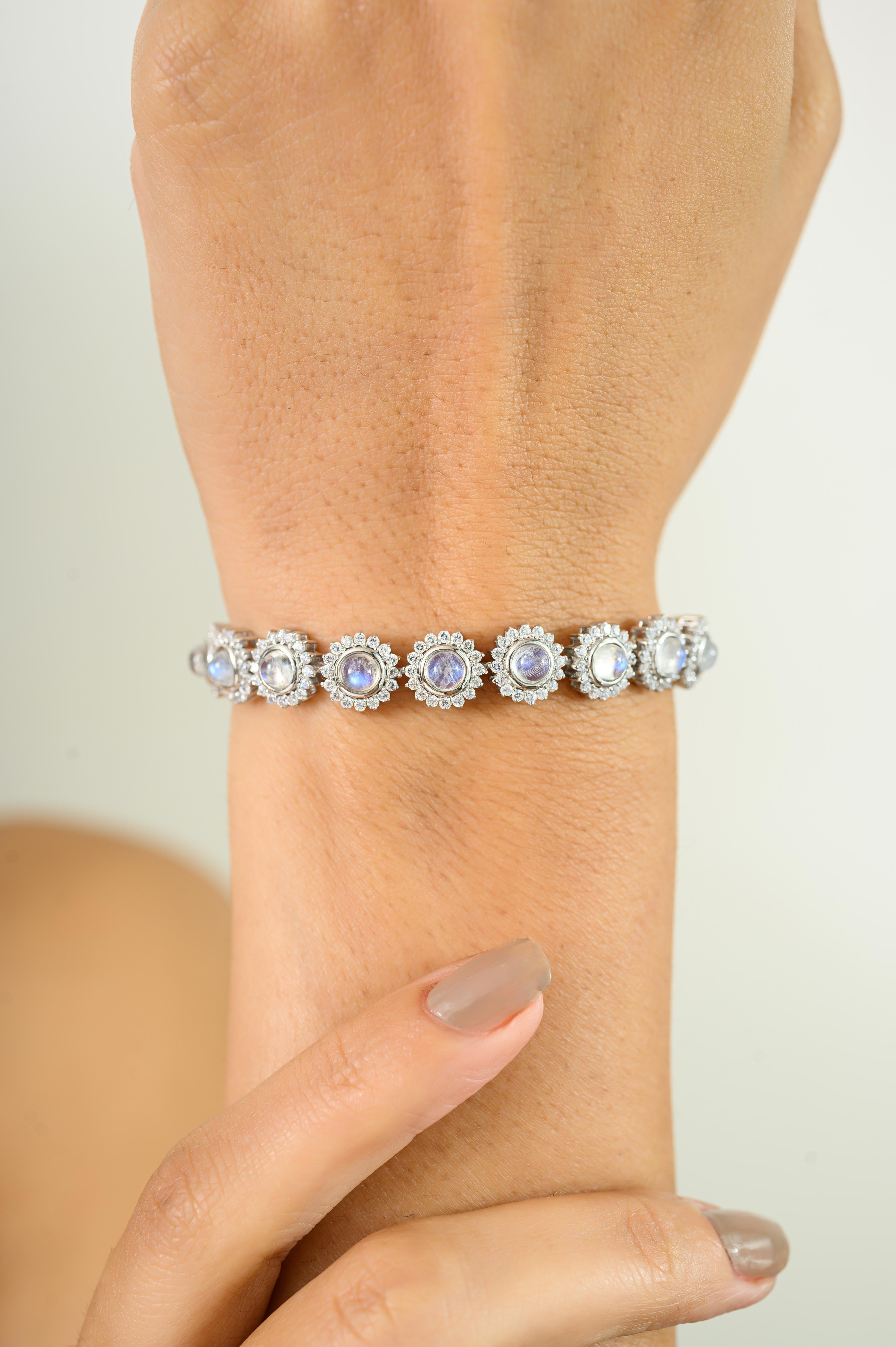 Questo è un braccialetto tennis con pietra lunare cabochons e un alone di piccole pietre CZ in argento. Eleva la tua collezione di gioielli con questo squisito braccialetto tennis realizzato in argento 925. Con pietre lunari rotonde incastonate a