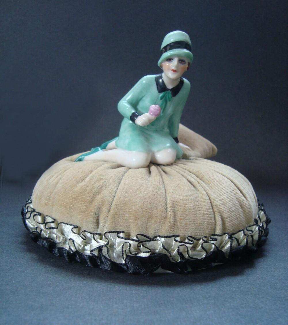 This piece is absolutely gorgeous, and complete with half doll and pincushion together. The porcelain half doll has wonderful mint green colour dress and cloche hat to match with black accents to hat, collar and wrists. Holding a pink rose in one