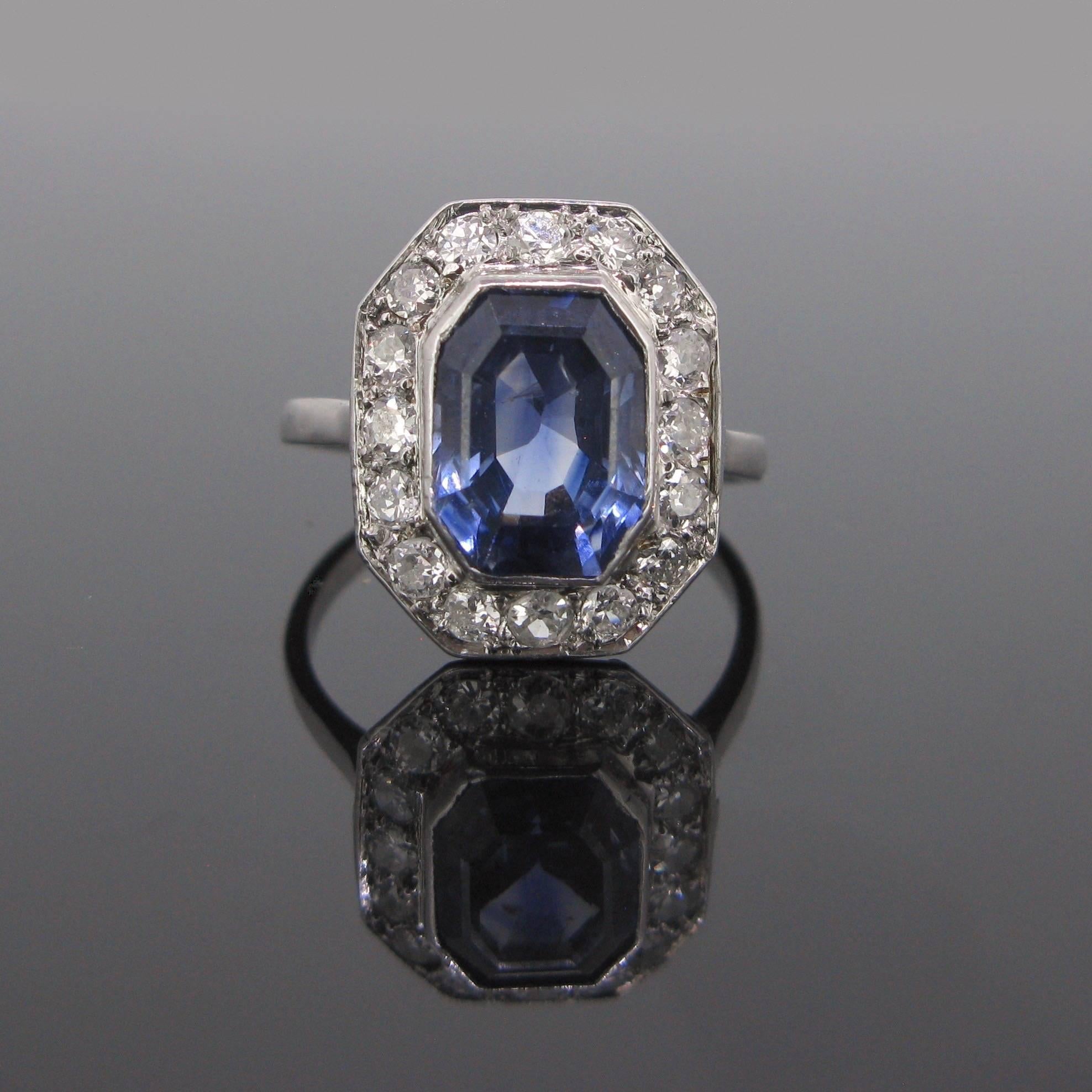 This ravishing ring features a beautiful navy blue sapphire surrounded with diamonds. The natural sapphire has a rectangular step cut, it weighs around 5.30ct and it is from Ceylon. The 16 diamonds weighs approximately 1ct in total (H/VS-SI).
The