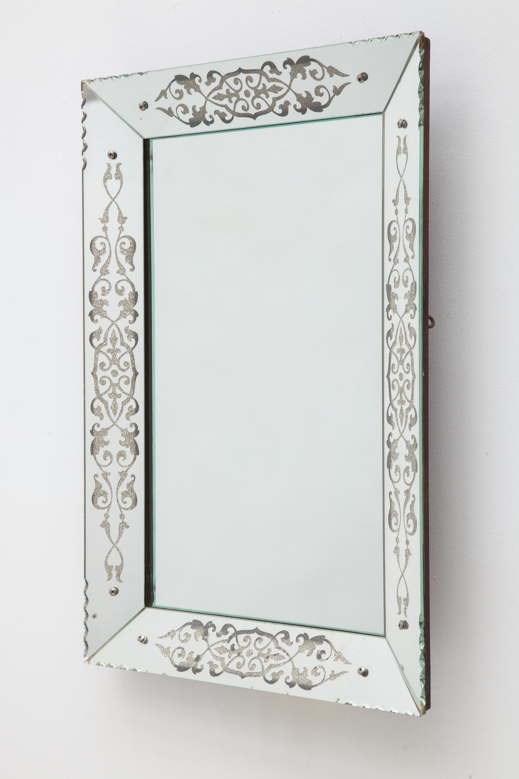 A rectangular Art Deco Mirror with scalloped corners. Features a sparkly flourish motif. Backed by a
wood frame.