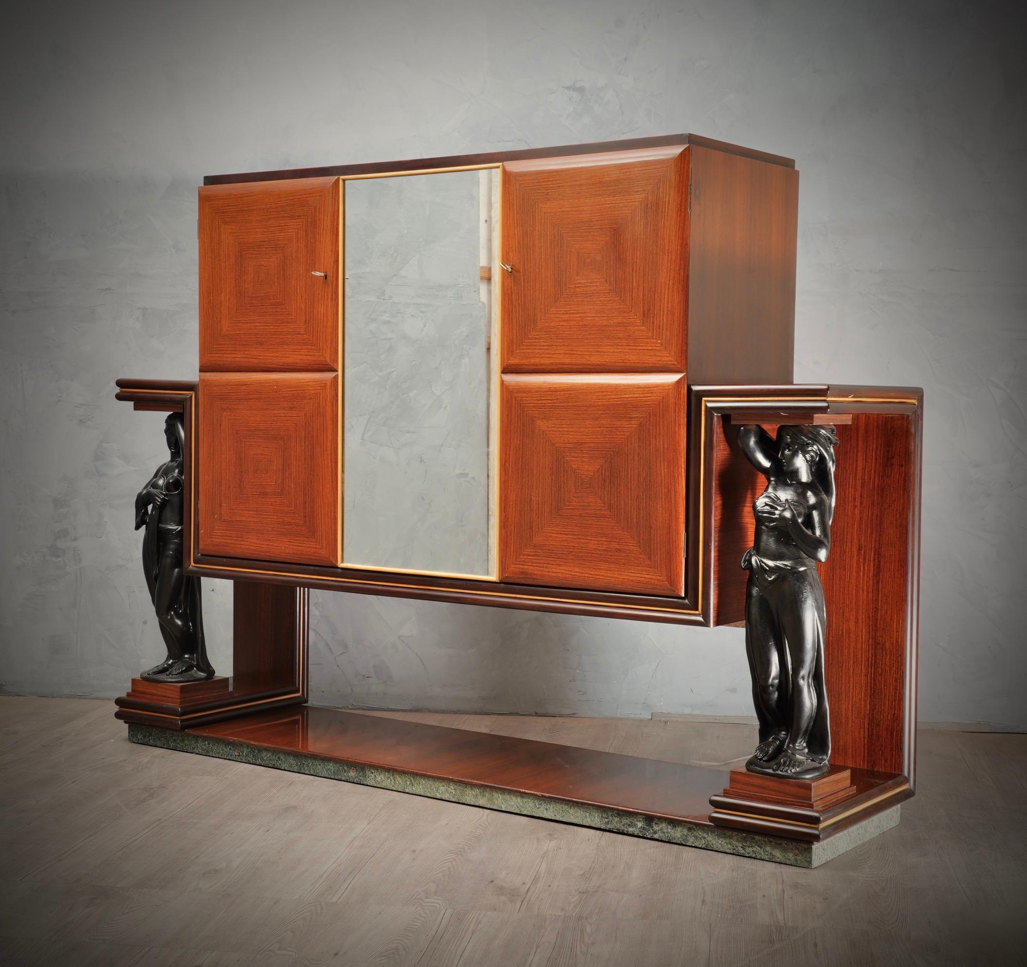 Beautiful bar cabinet in characteristic Italian style of Paolo Buffa, Vittorio Dassi and Osvaldo Borsani.

All veneered in walnut wood. The cabinet is formed by a central body whit three doors, and two wooden sculptures polished in black lacquer
