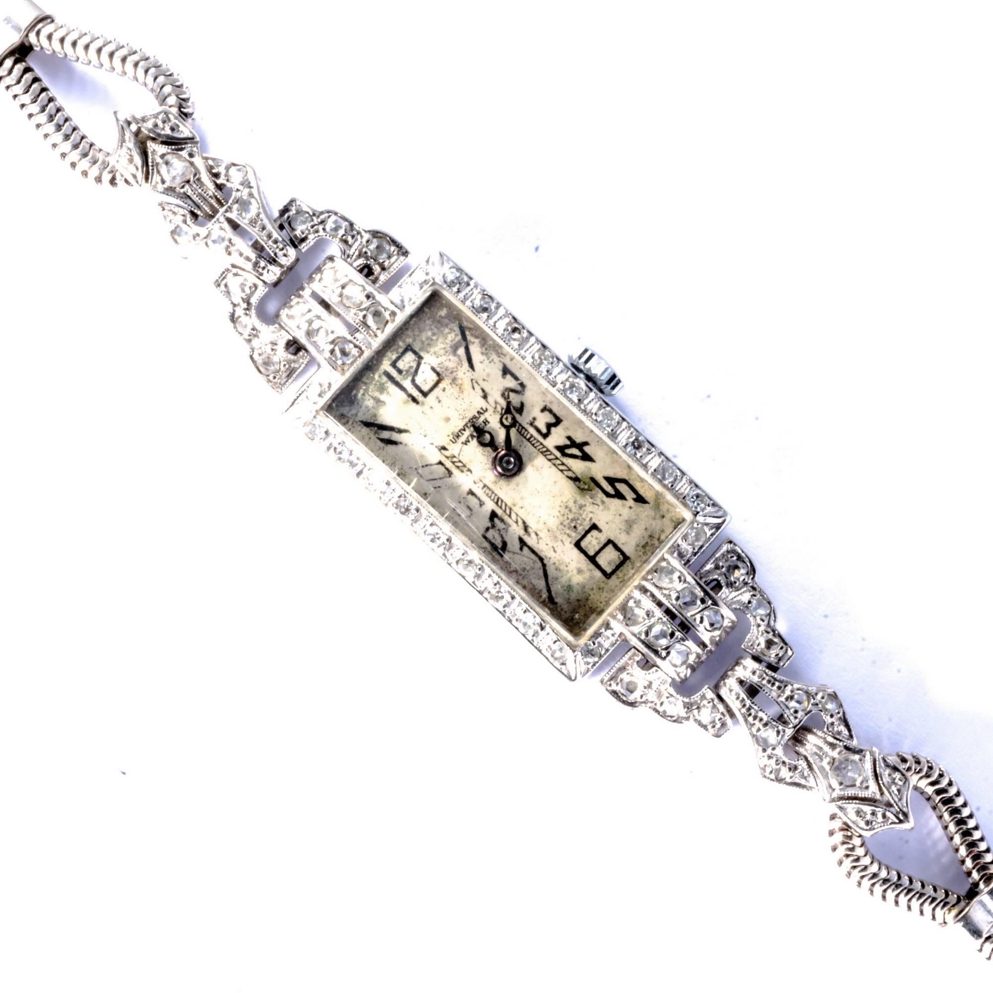 Elegant and ultra-flat ladies' wristwatch made in Switzerland before the manufacturer, the Universal Watch,  moved to Geneva in 1929. Original art déco, hand made in white gold 18 k, featuring filigree decorations with old mine and huit-huit cut