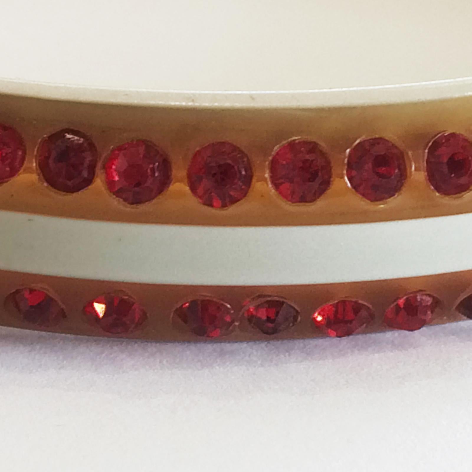 Art Deco Bangle in early Honey and cream Celluloid, highlighted with double ring of Red Diamantes. The perfect circle in shape, and so finely jointed, you need to search to see it. Because of the design, some of the red diamantes catch the light and