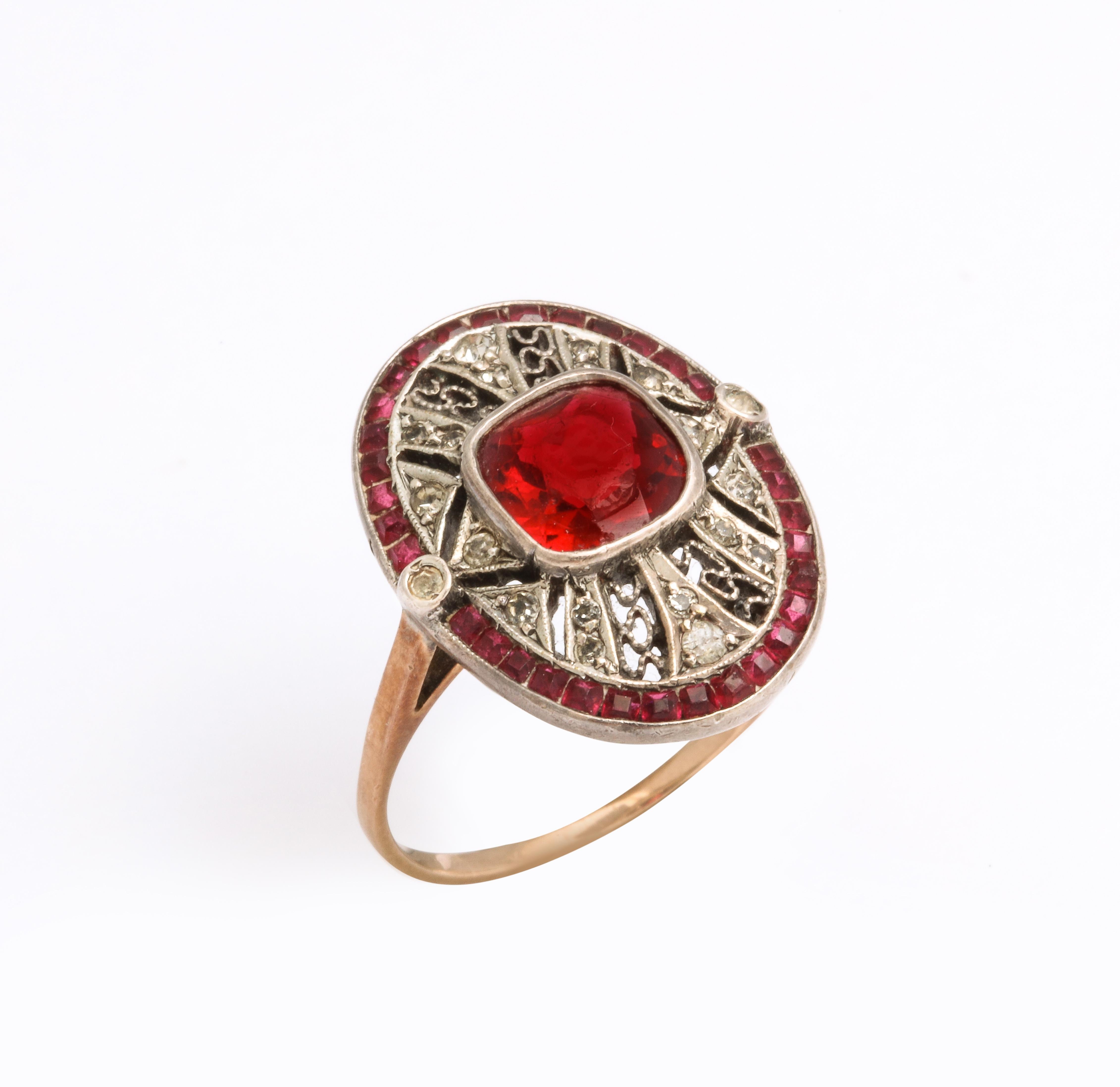 If you see a ruby and diamond ring  think again as you are looking at a red paste cabriolet bordered ring with white paste in a the lace pattern. The face of this ring is centered by a rectangular cut red paste gem. The ring is very well made with a