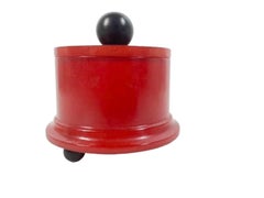 Boîte en bakélite rouge de forme cylindrique, pieds et poignée en bakélite noire Art déco