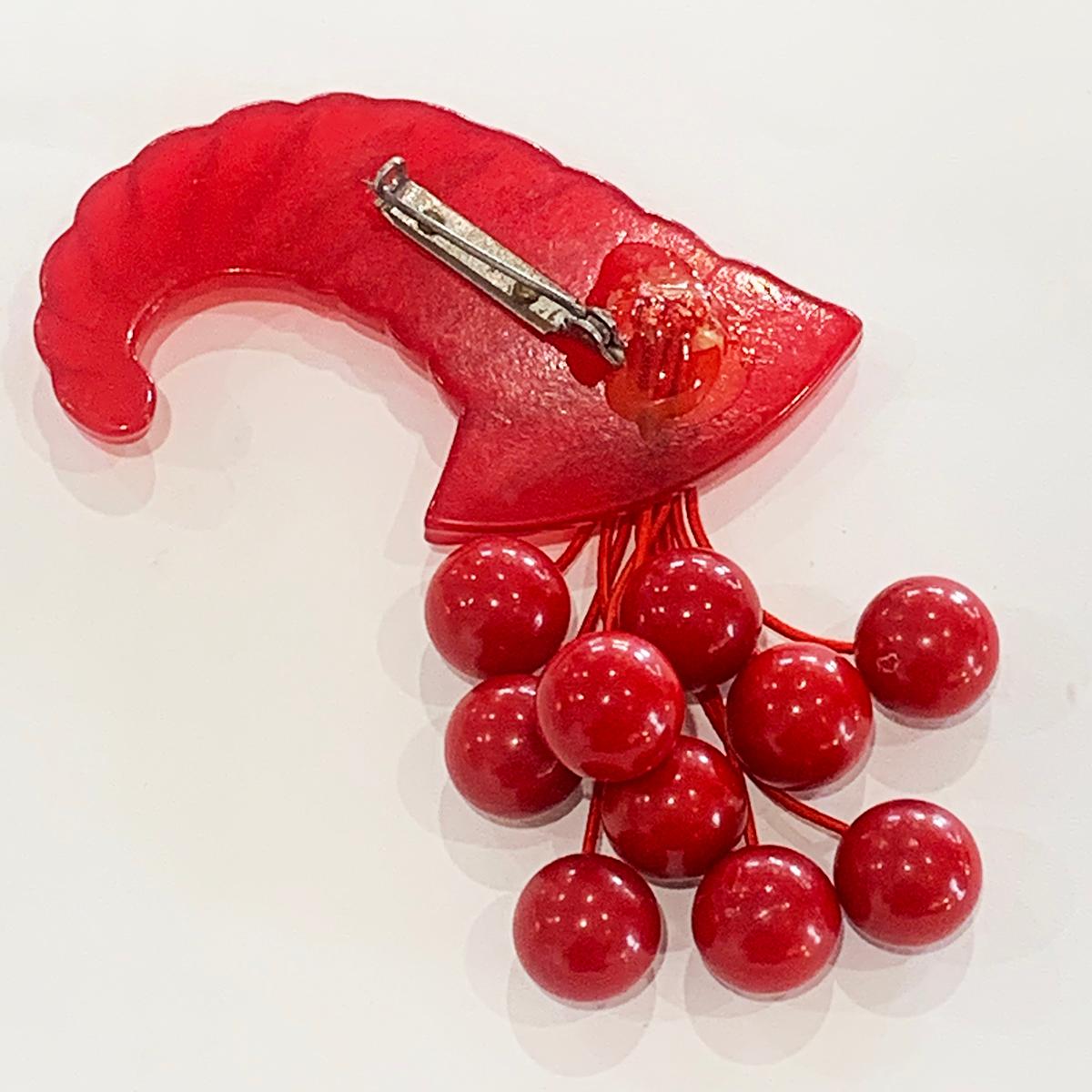 Art Deco Carved Red Bakelite Horn of Plenty brooch or pin with cherries. A truly wonderful creation in Red bakelite. The cherry stems and whole brooch (pin) is original with no repairs or losses; original “gum” holding the cherry stalks, and the pin