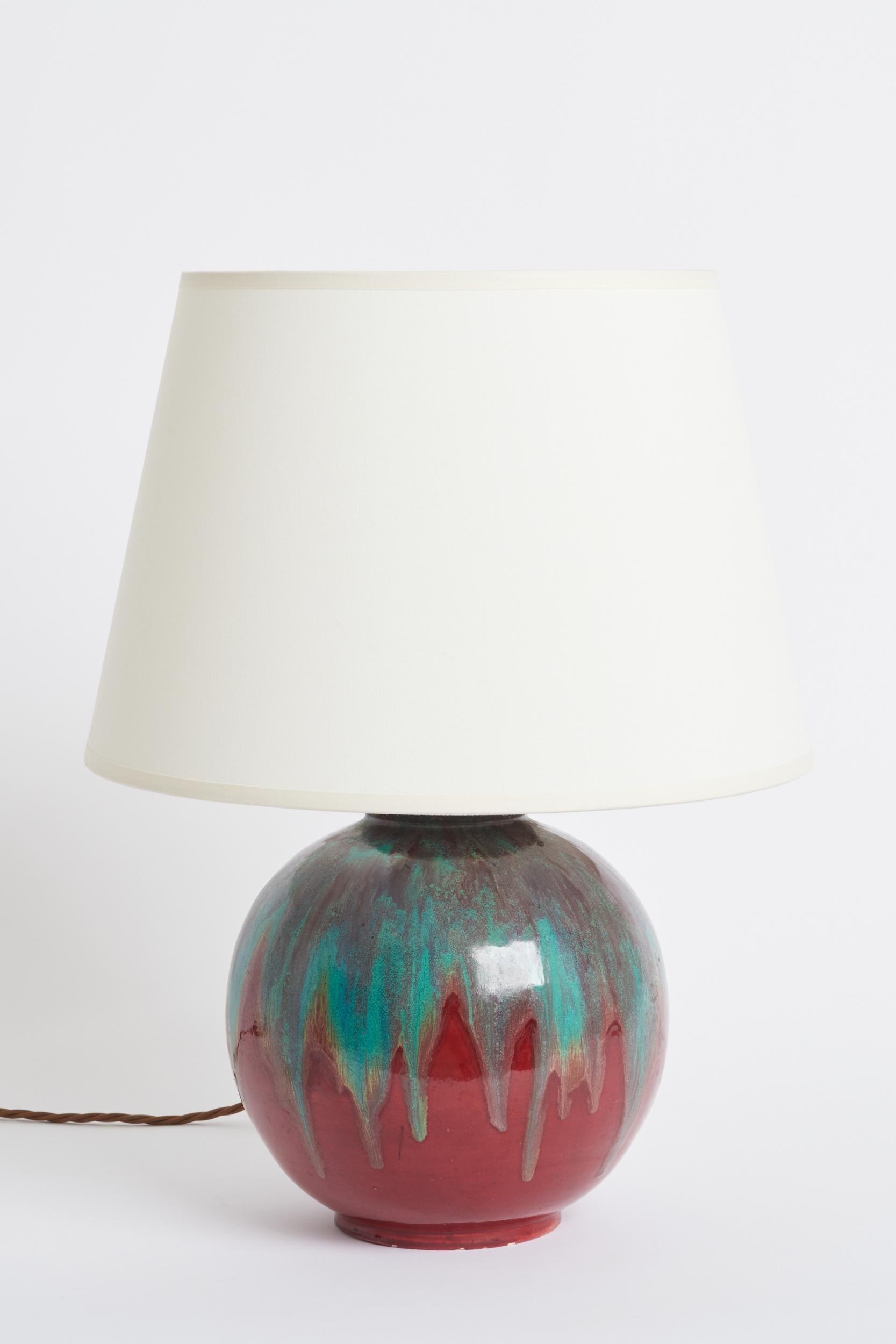 A polychrome ceramic table lamp by Félix Gete (1870-1959) for CAB (Ceramique d'Art de Bordeaux). Sang de boeuf with turquoise dripping enamel. Signed and stamped. 
France, 1920s
With the shade: 44.5 cm high by 30.5 cm diameter
Lamp base only: 28 cm