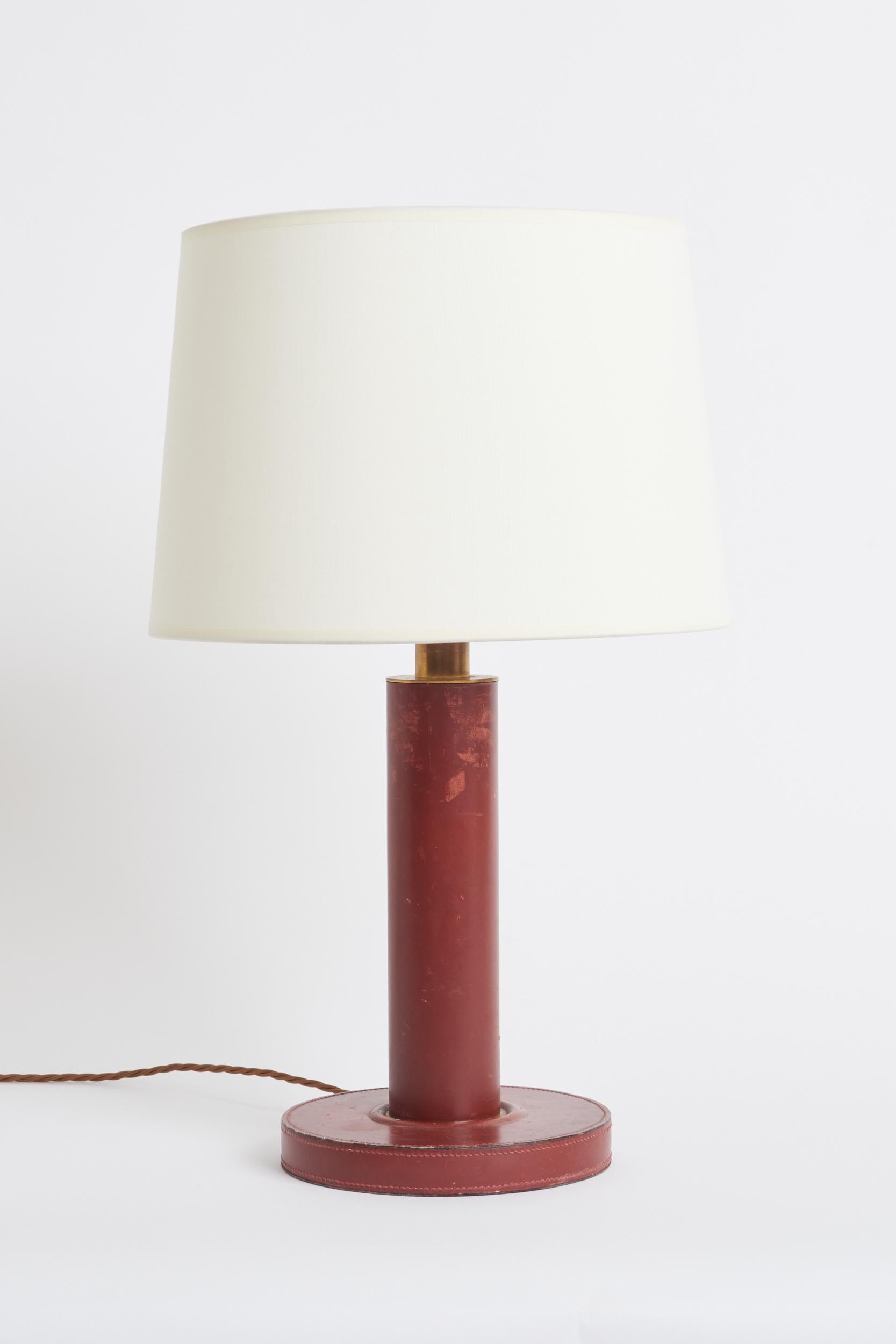 Lampe de table en cuir rouge, à la manière de Paul Dupre Lafon.
France, années 1930.
Avec l'abat-jour : 57,5 cm de haut par 35,5 cm de diamètre
Base de la lampe uniquement : 39 cm de haut par 20 cm de diamètre.