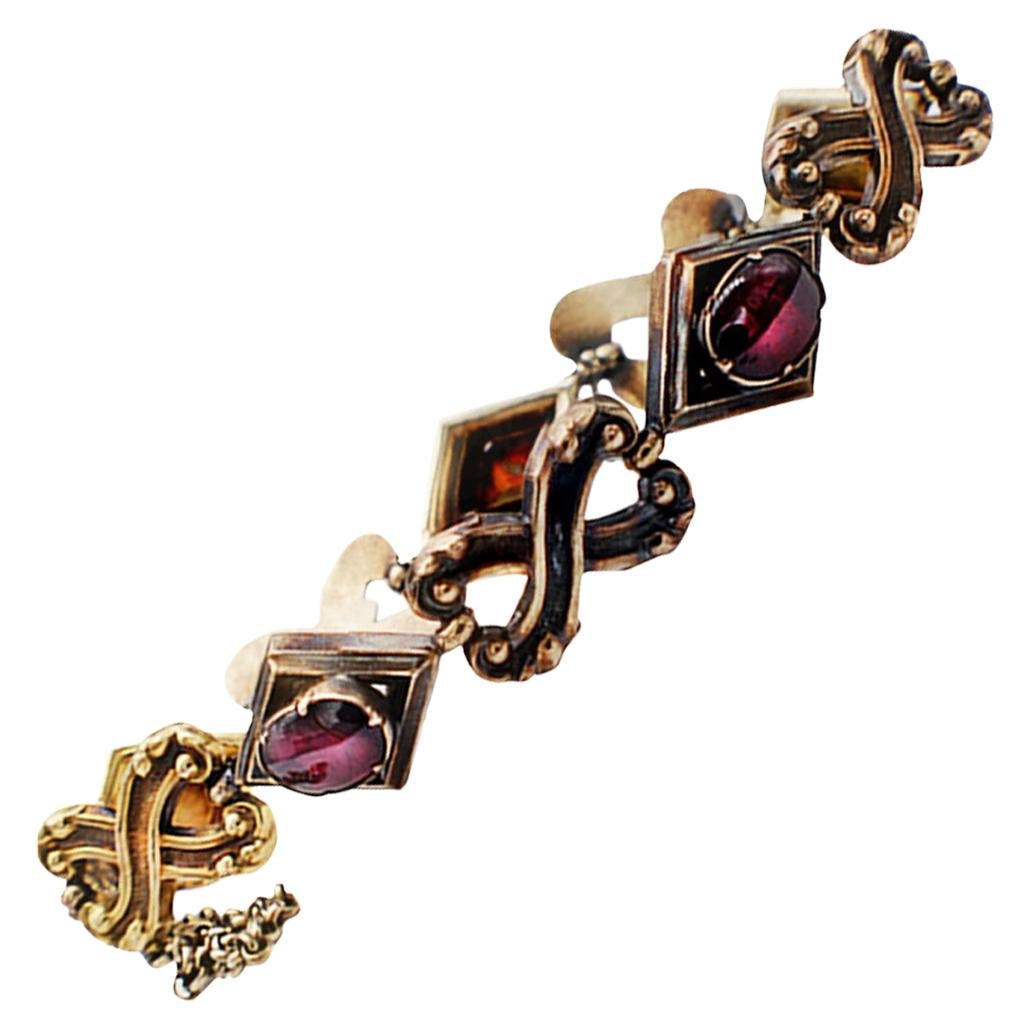 Art Deco, Red Stone two-toned gold Bracelet
 Circa 1940's bracelet features bowtie style links attaching red, bezel set stones measuring 8 x 6 mm. The metal has been tested as 10-13 Karat. The links are yellow gold and white . There is a safety link