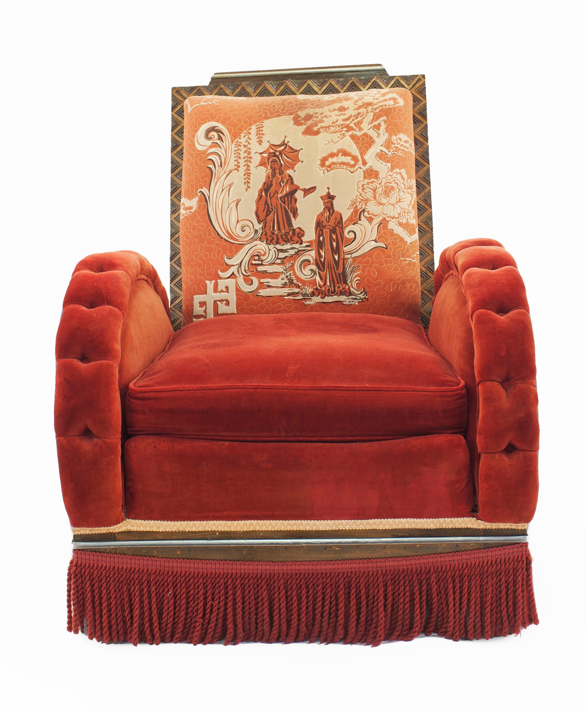 American Art Deco red velvet upholstered arm chair with tufted arch form arms and a Chinese scene painted back in a geometric carved frame