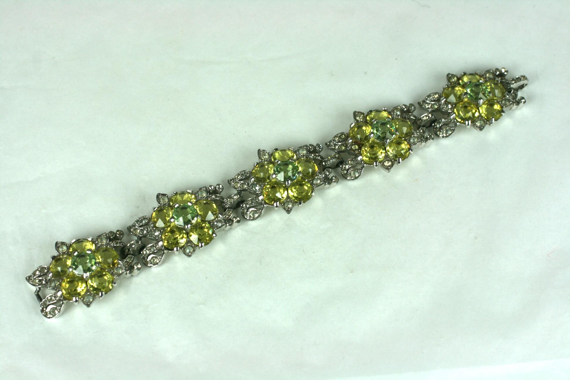 Art Deco Reja flower head link bracelet. Composed of round faux citrine and green sapphire faceted stones set in rhodium plate base metal. With crystal rhinestone pave accented leaves in each link.
Excellent Condition, Unsigned. 1930's  USA.
Length